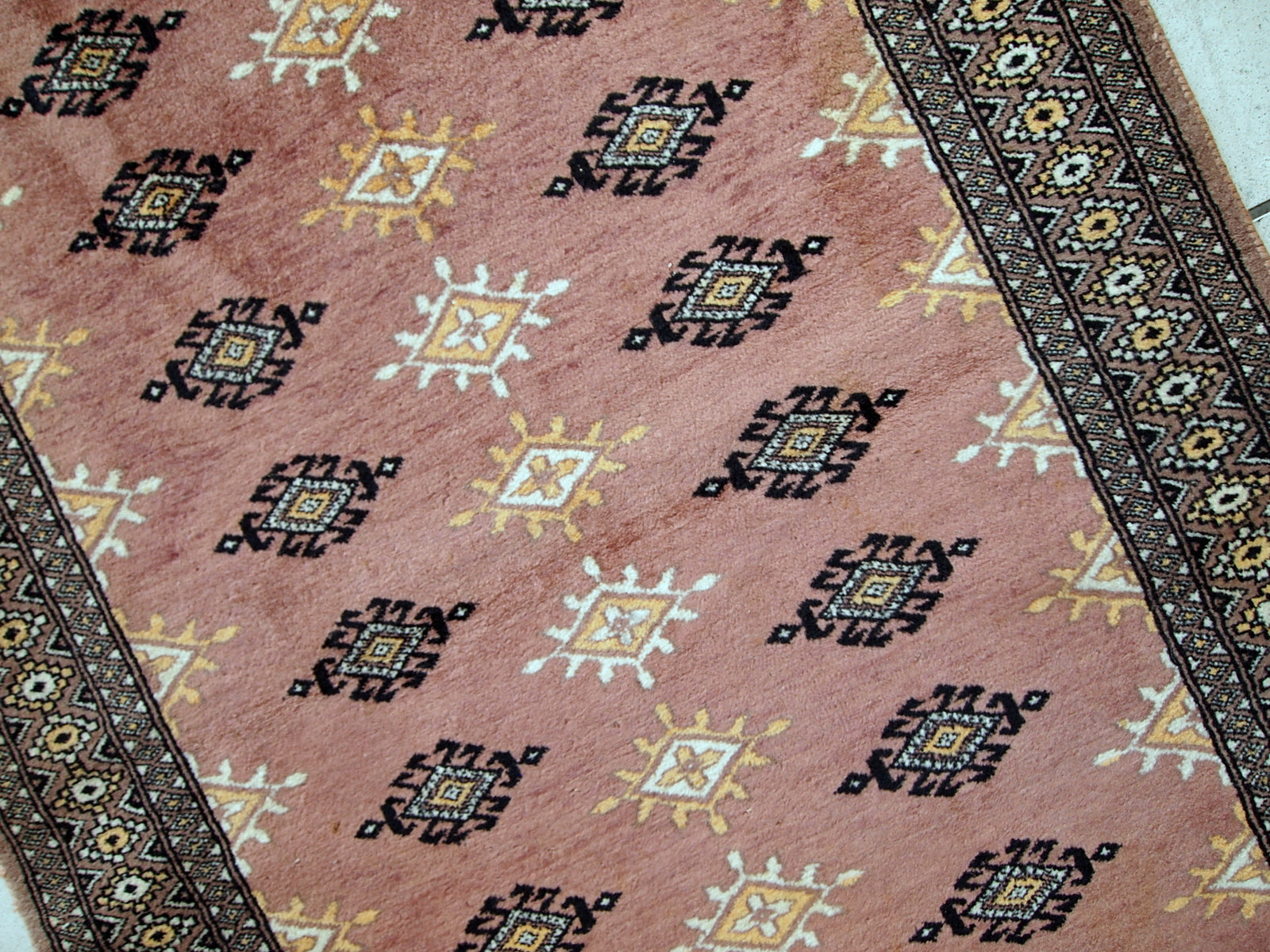 Handmade vintage Uzbek Bukhara rug in original good condition. The rug made in soft wool of peach shade. 