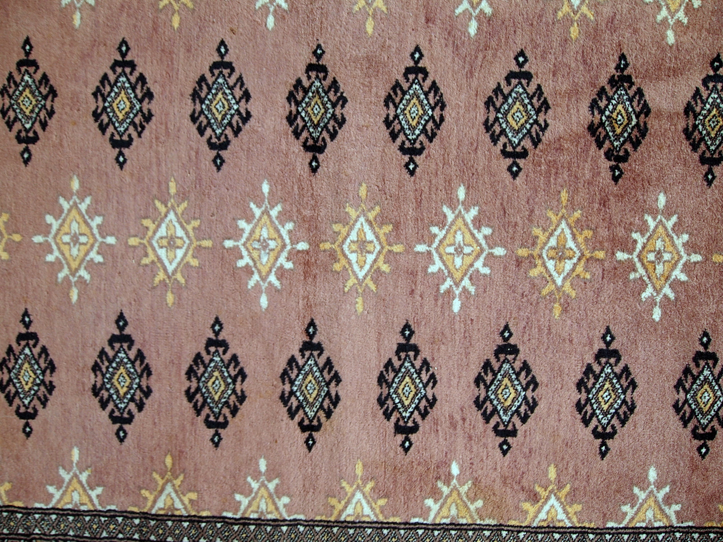 Handmade vintage Uzbek Bukhara rug in original good condition. The rug made in soft wool of peach shade. 
