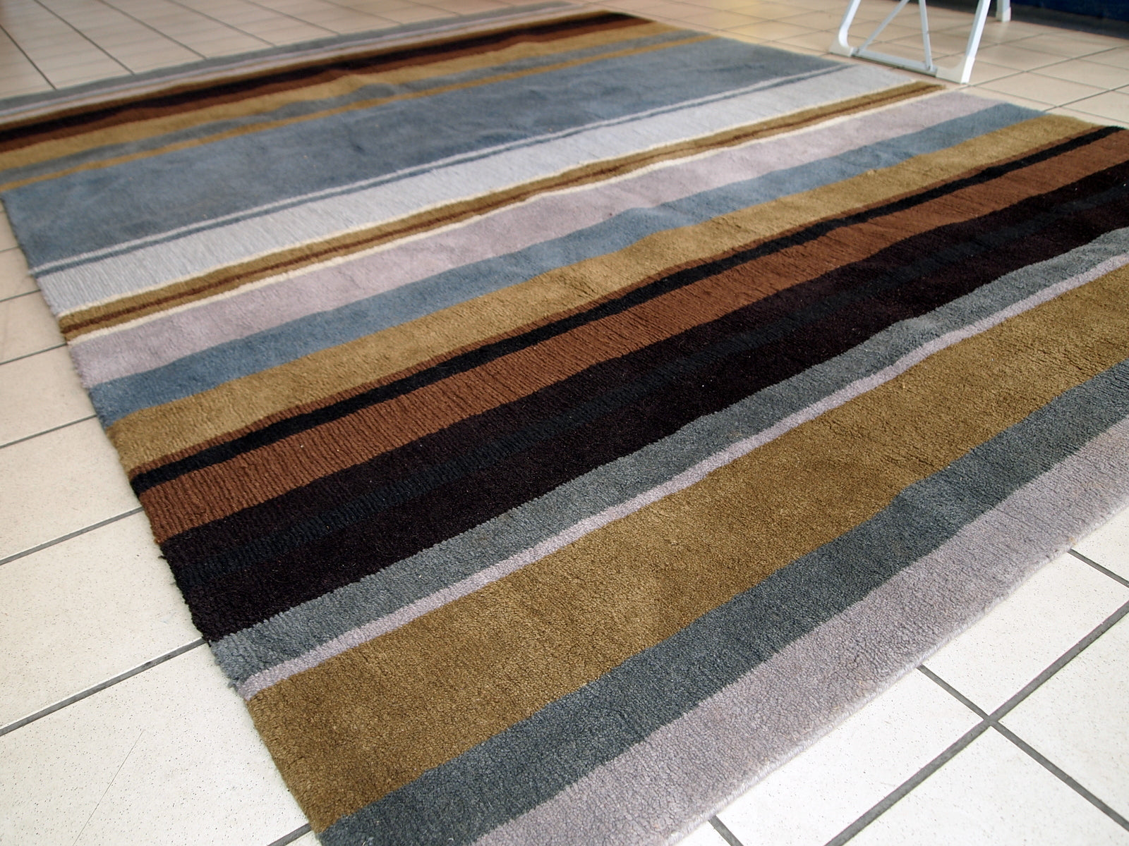 Vintage handmade Indian striped rug in blue, purple and different shades of brown. Each line of the rug made in different technics as well, so the pattern on it changes. The rug is very thick, heavy and soft, made out of wool. 