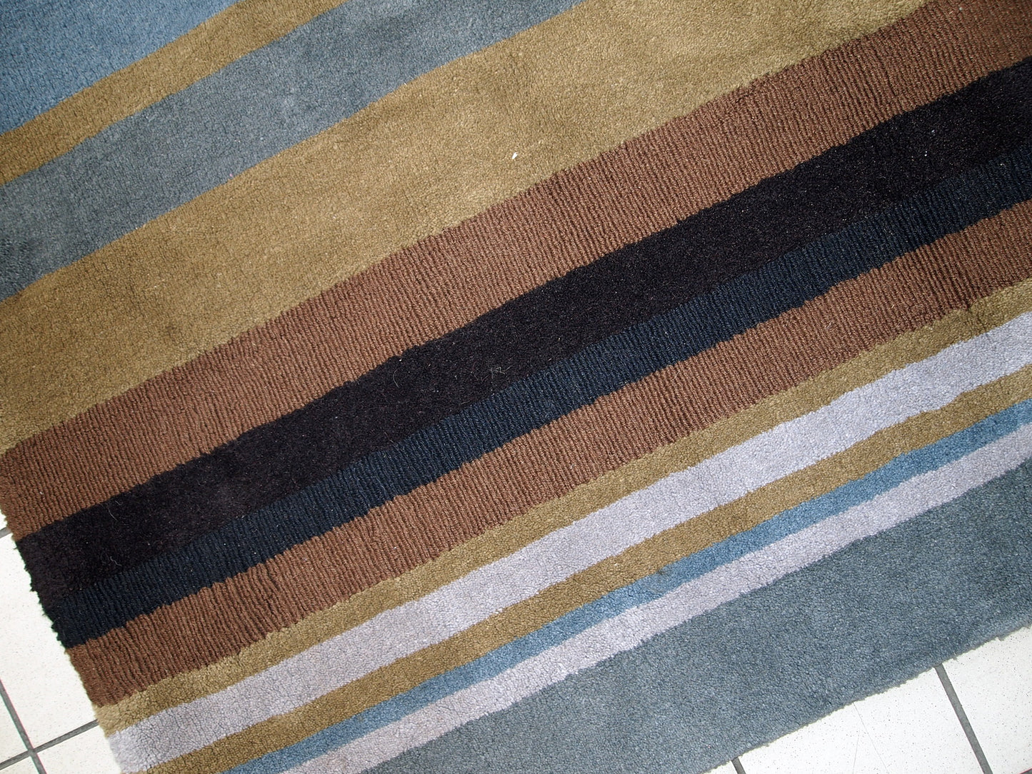 Vintage handmade Indian striped rug in blue, purple and different shades of brown. Each line of the rug made in different technics as well, so the pattern on it changes. The rug is very thick, heavy and soft, made out of wool. 