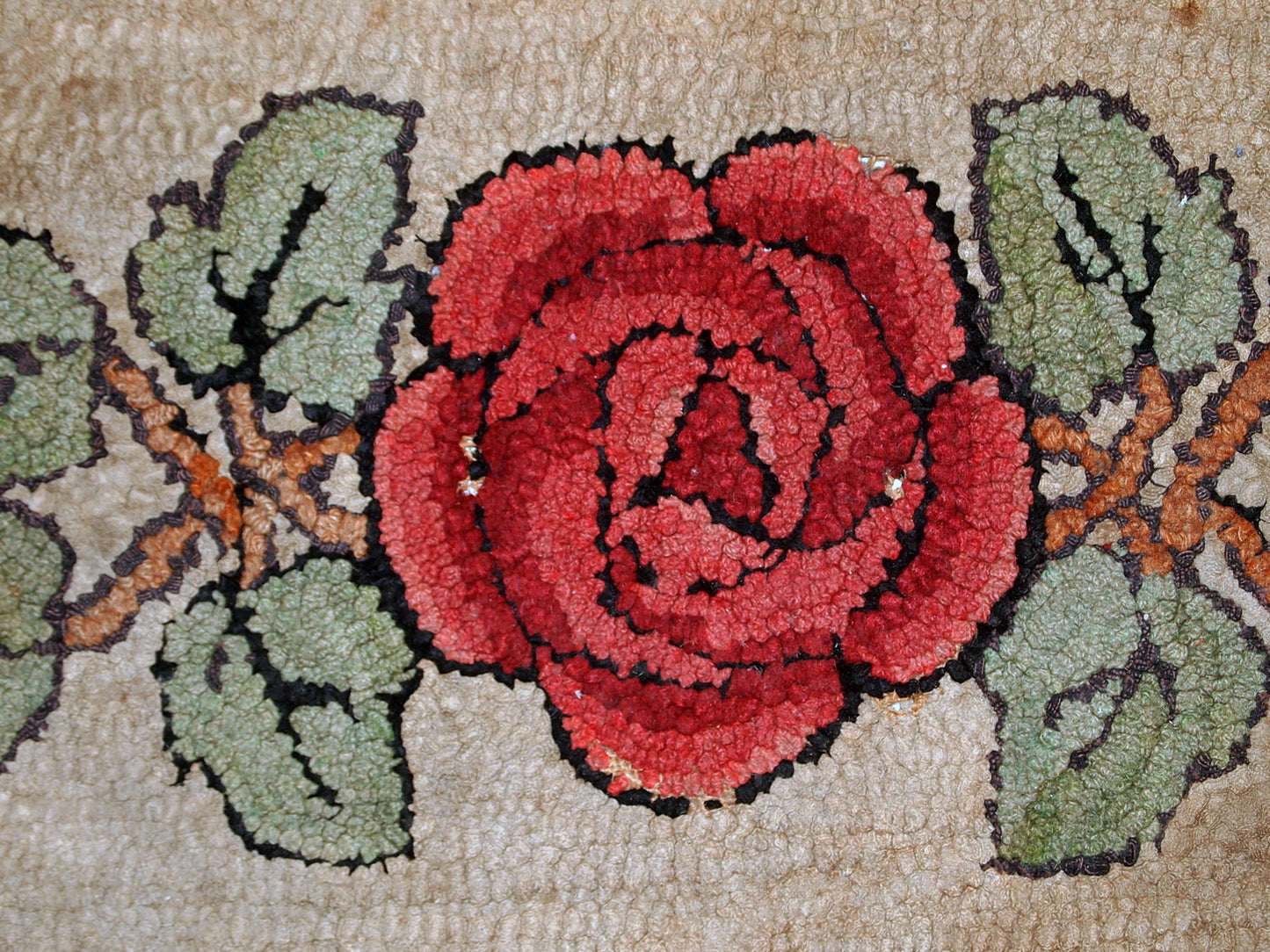 Antique American primitive hooked rug in floral design. The rug has been restored but it has some age discolorations on the light background. 