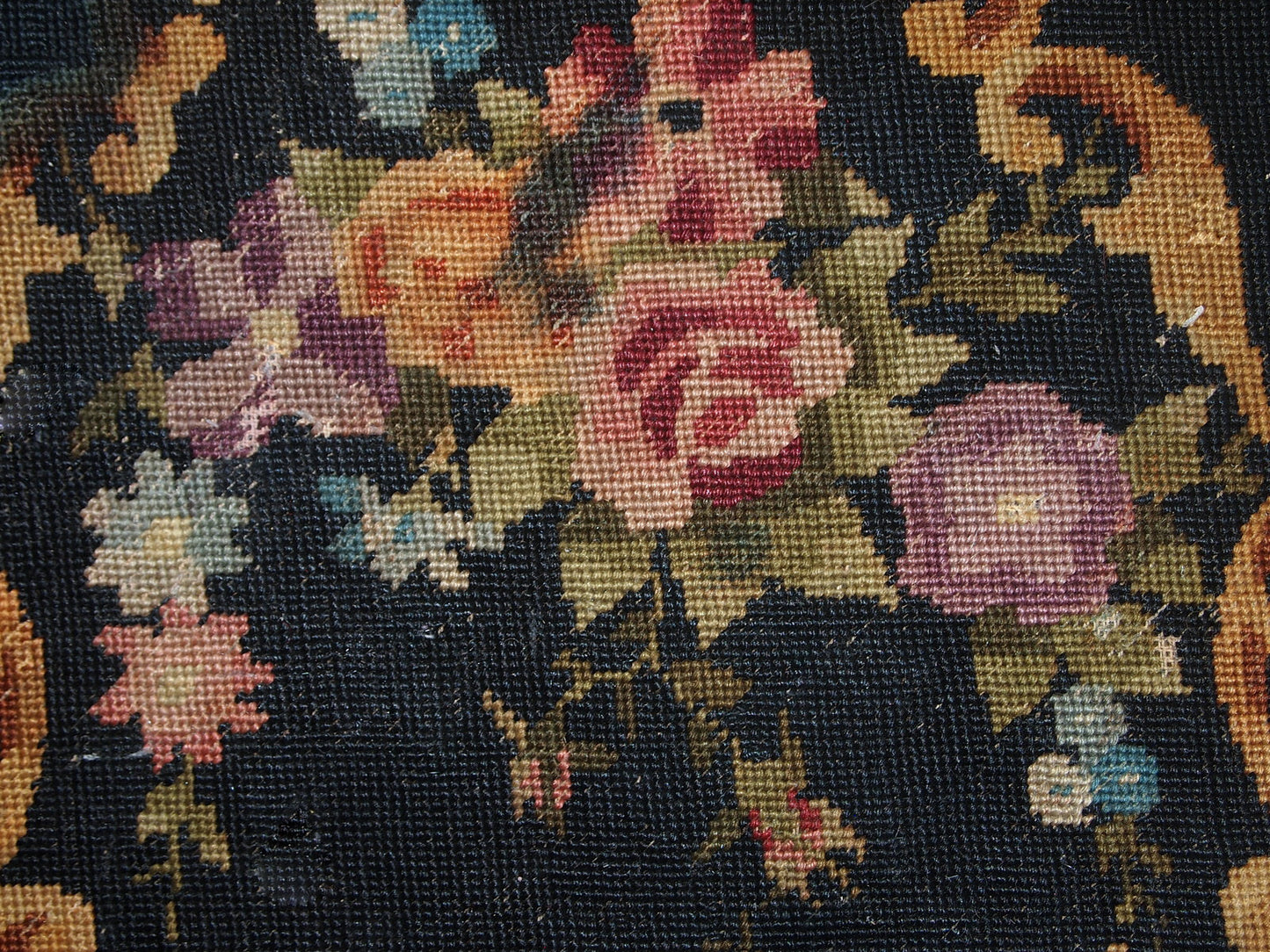 Handmade antique unframed English Needlepoint in black colour with floral design. The size of actual needlepoint is 1.3' x 1.4' (42cm x 45cm) and with the sides is 2' x 2.2' (63cm x 68cm). It is in original condition, it has some discolourations on the side areas. It can be framed or attached to a decorative pillow, chair etc.