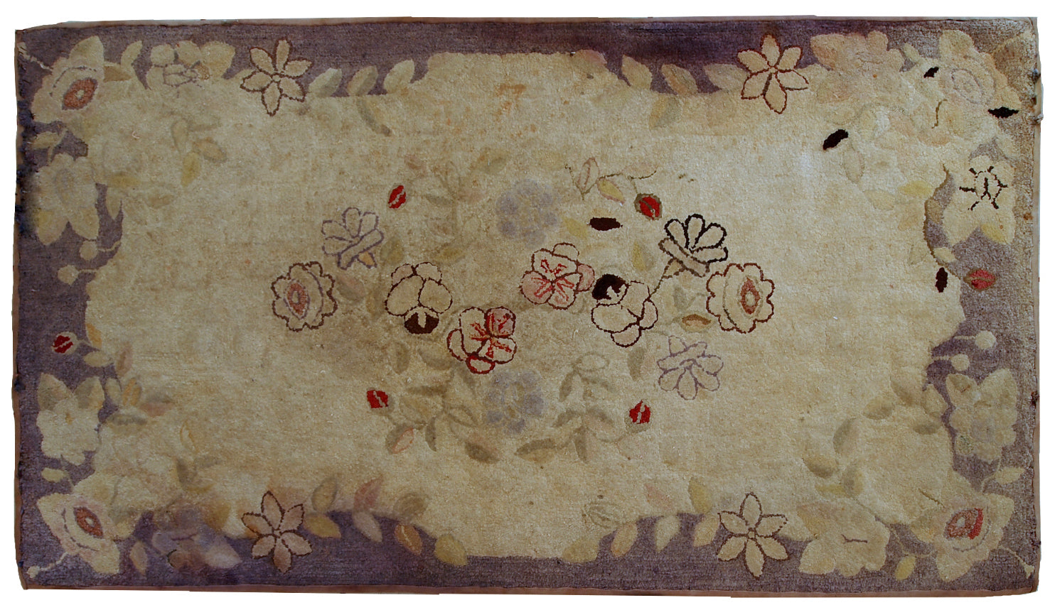 Handmade antique American Primitive Hooked rug in beige shade with abstract/floral design. The border is purple. It is in good condition.