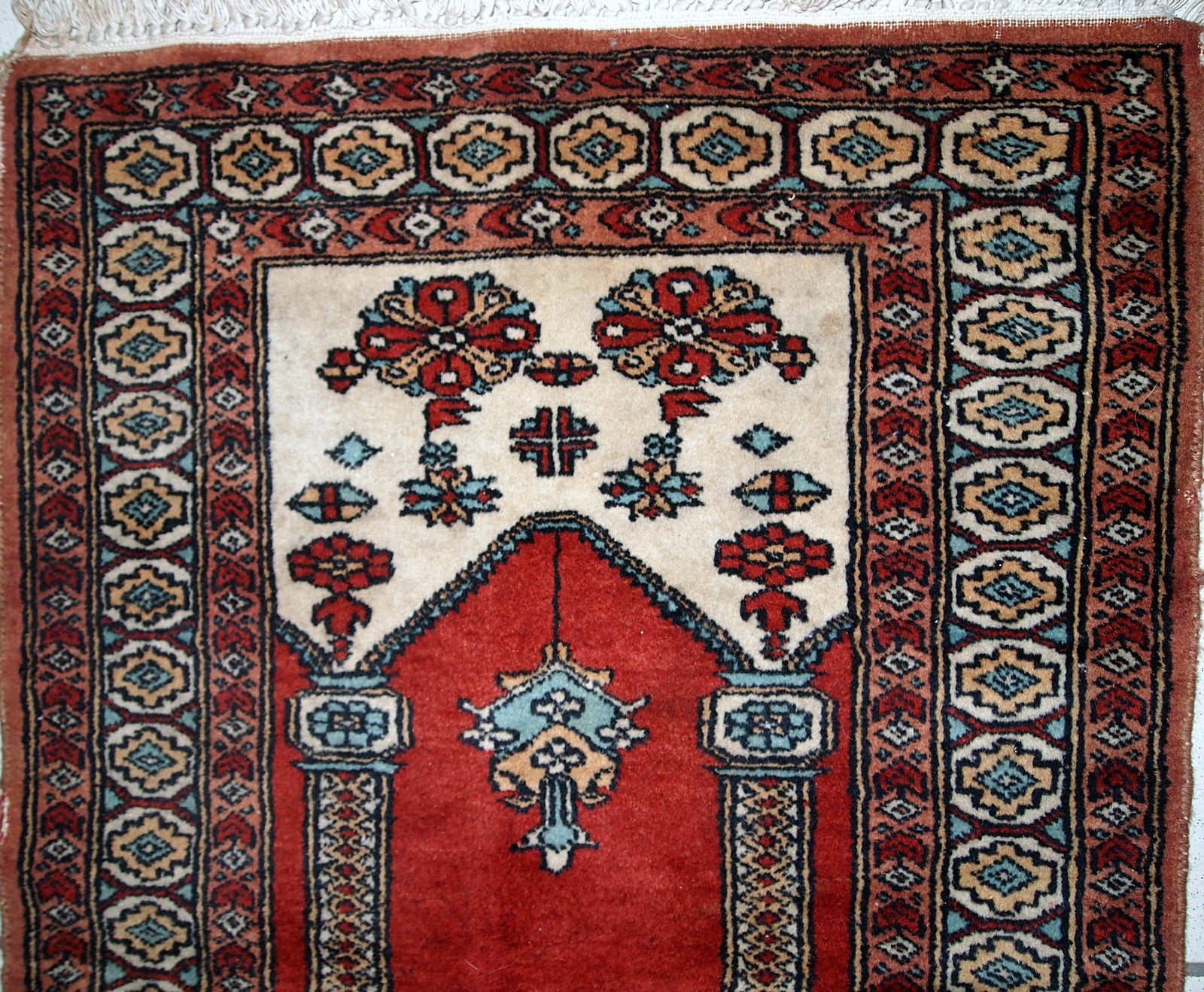 Handmade vintage prayer Pakistani Lahore rug in original good condition. The rug is in bright shade of red and beautiful decorative border.