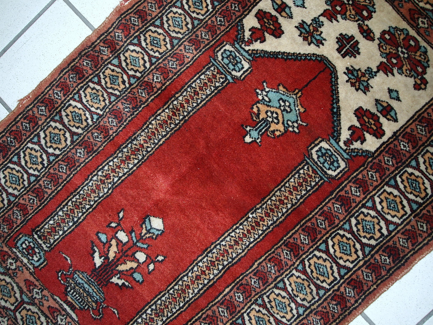 Handmade vintage prayer Pakistani Lahore rug in original good condition. The rug is in bright shade of red and beautiful decorative border.