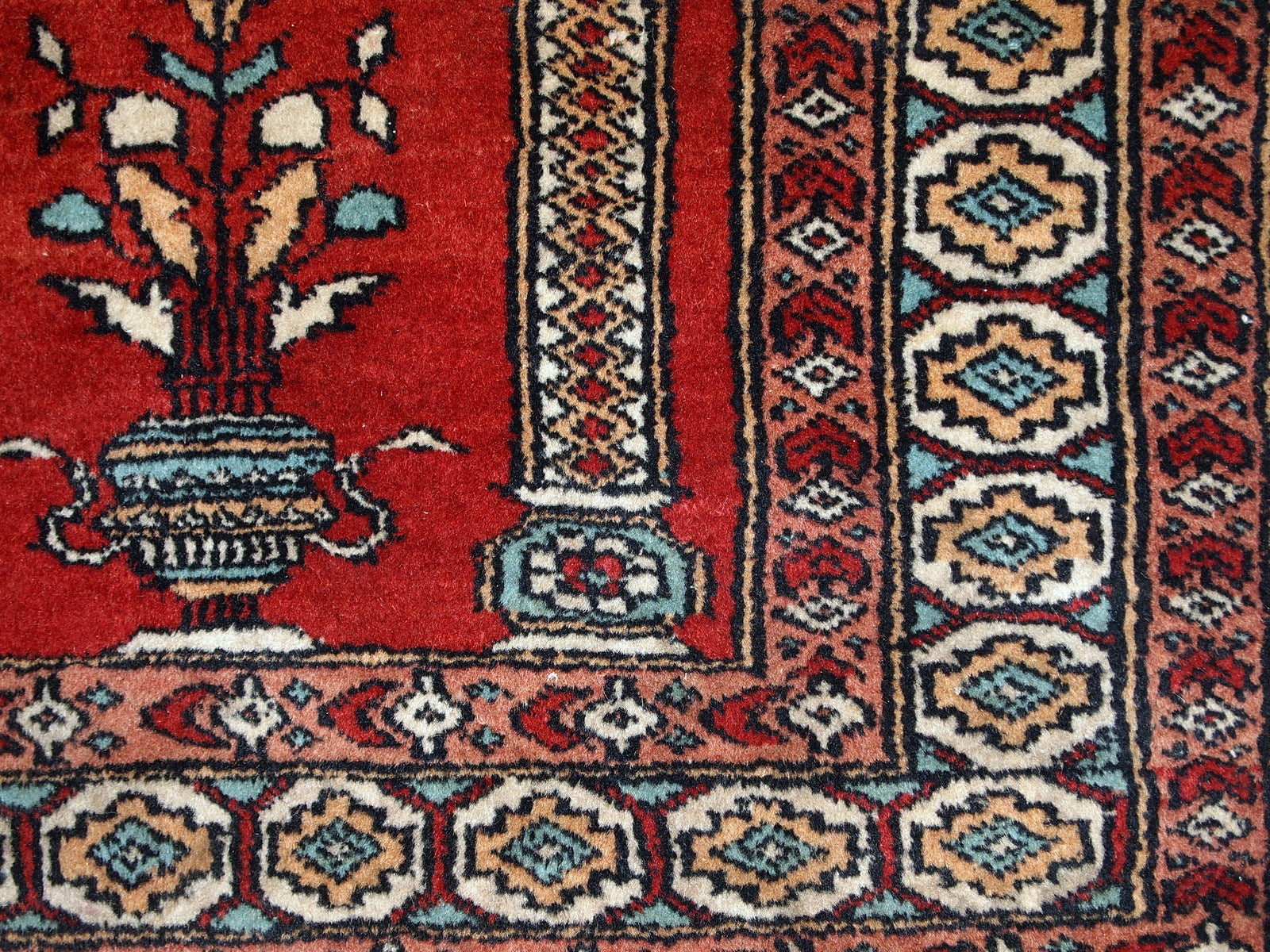 Handmade vintage prayer Pakistani Lahore rug in original good condition. The rug is in bright shade of red and beautiful decorative border.