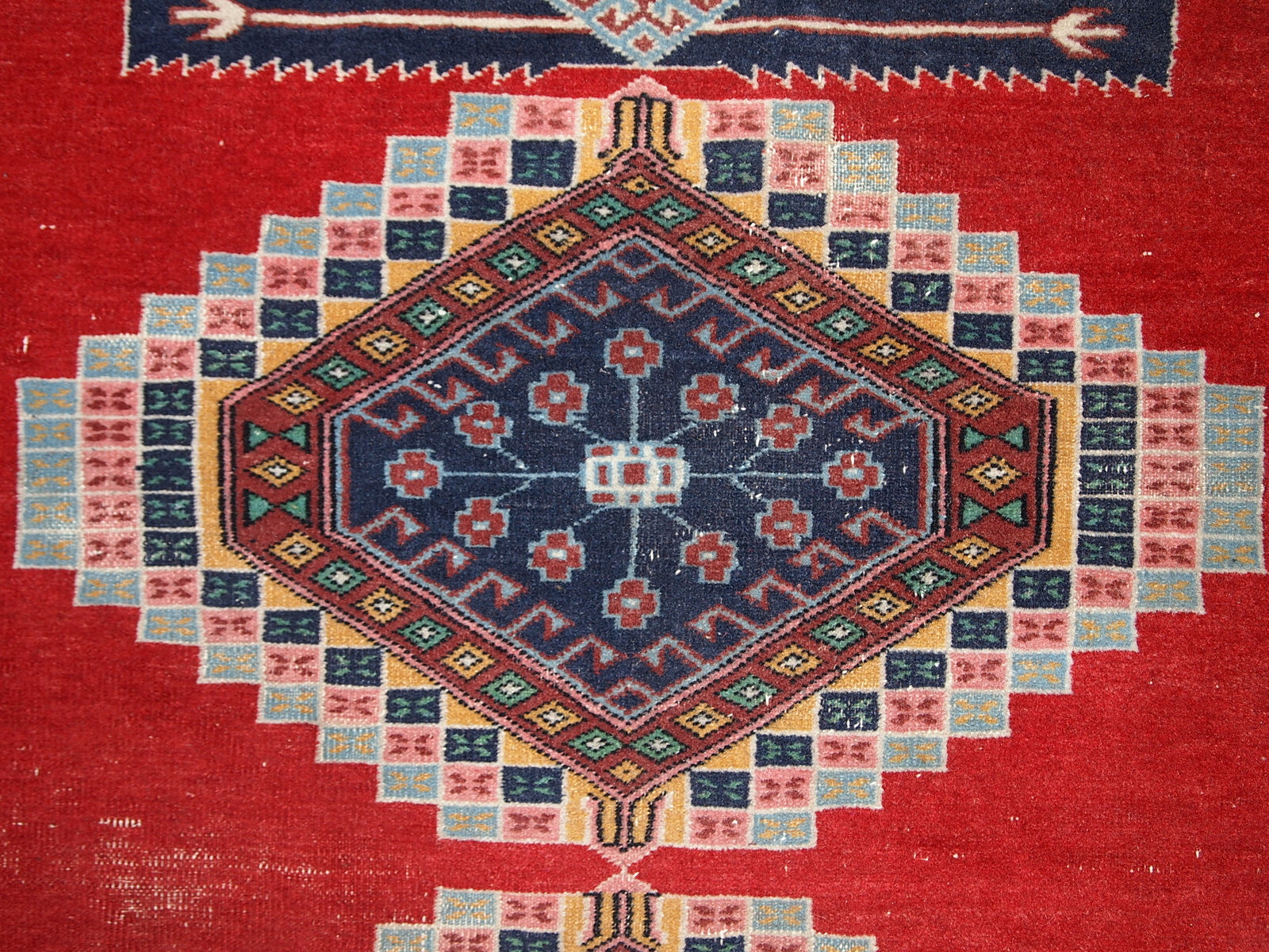 Handmade vintage Uzbek distressed rug in bright red wool. It has been made in the middle of 20th century in Central Asia.