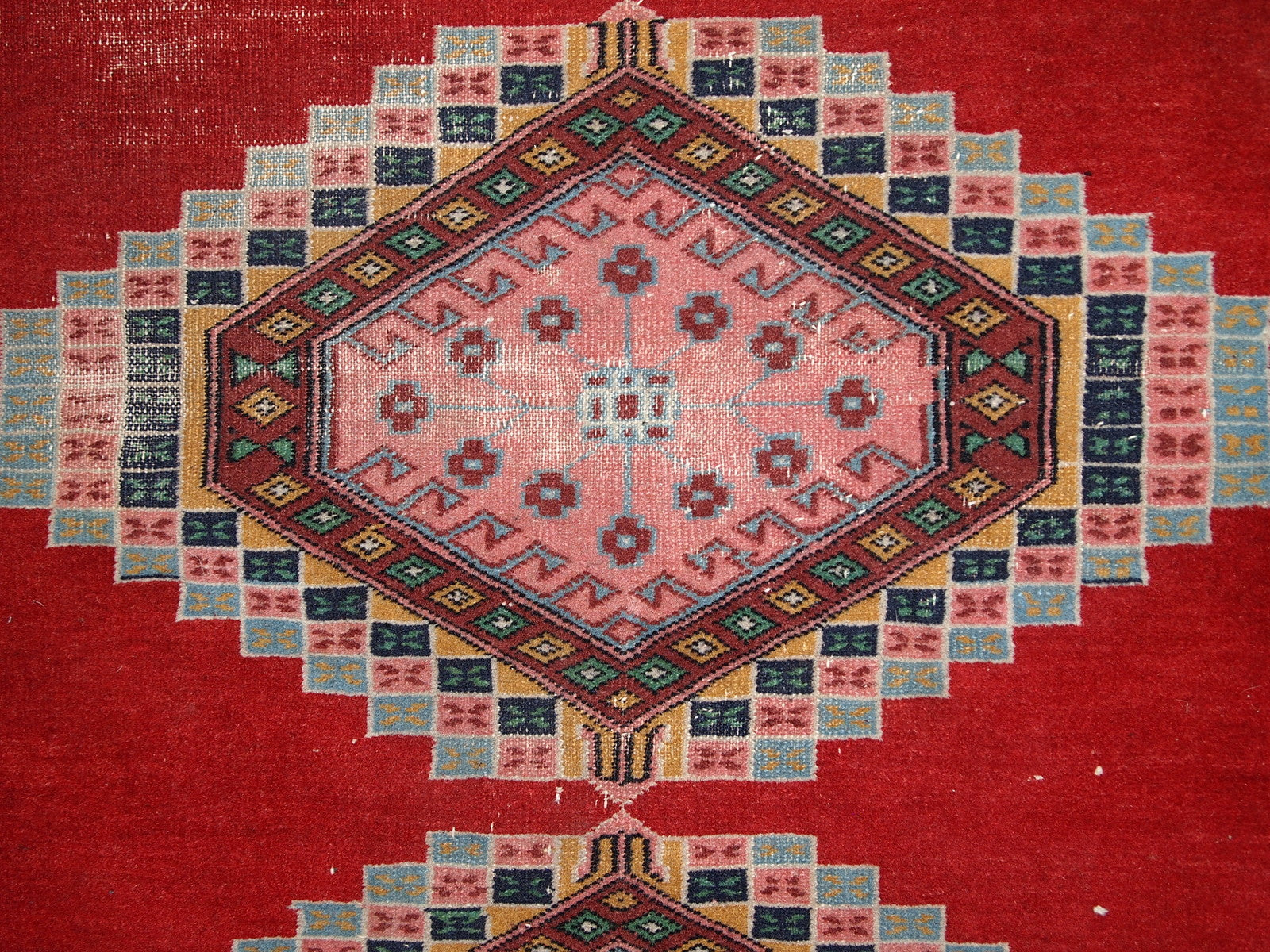 Handmade vintage Uzbek distressed rug in bright red wool. It has been made in the middle of 20th century in Central Asia.