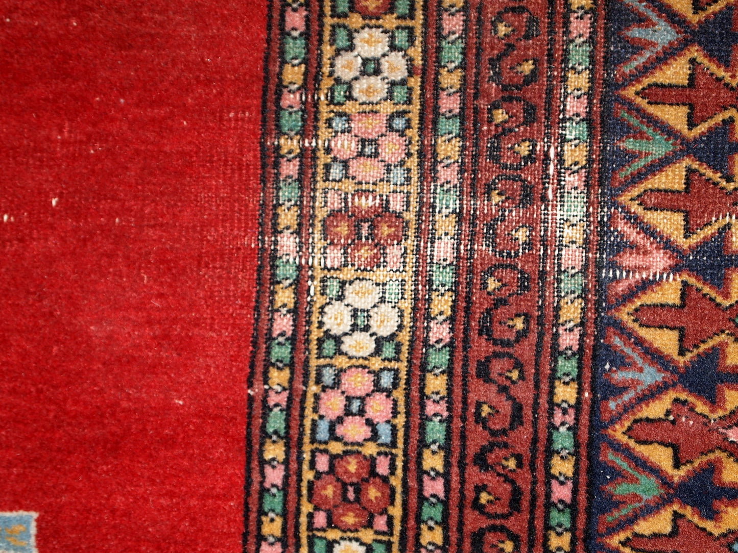 Handmade vintage Uzbek distressed rug in bright red wool. It has been made in the middle of 20th century in Central Asia.