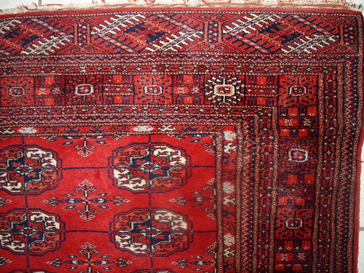 Vintage handmade Tekke rug from Turkmenistan in original good condition. It has been made in the end of 20th century in red wool.