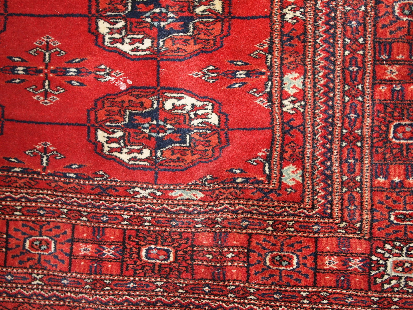 Vintage handmade Tekke rug from Turkmenistan in original good condition. It has been made in the end of 20th century in red wool.