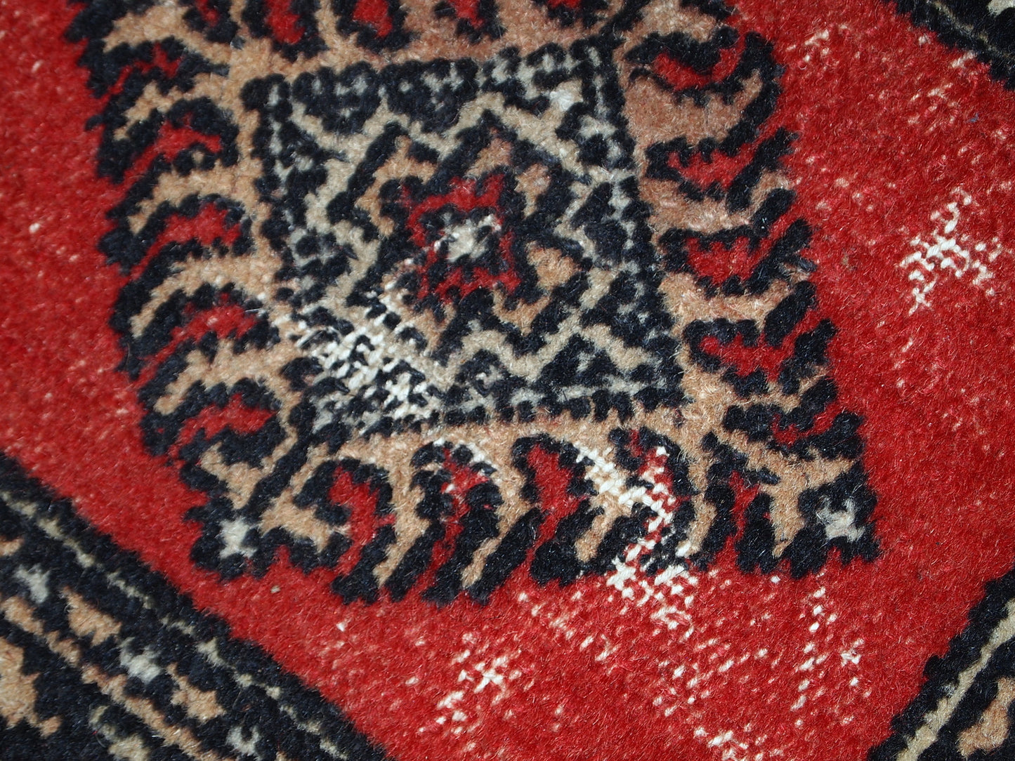 Vintage rug from Pakistan in distressed condition. The rug made in the end of 20th century in red wool.