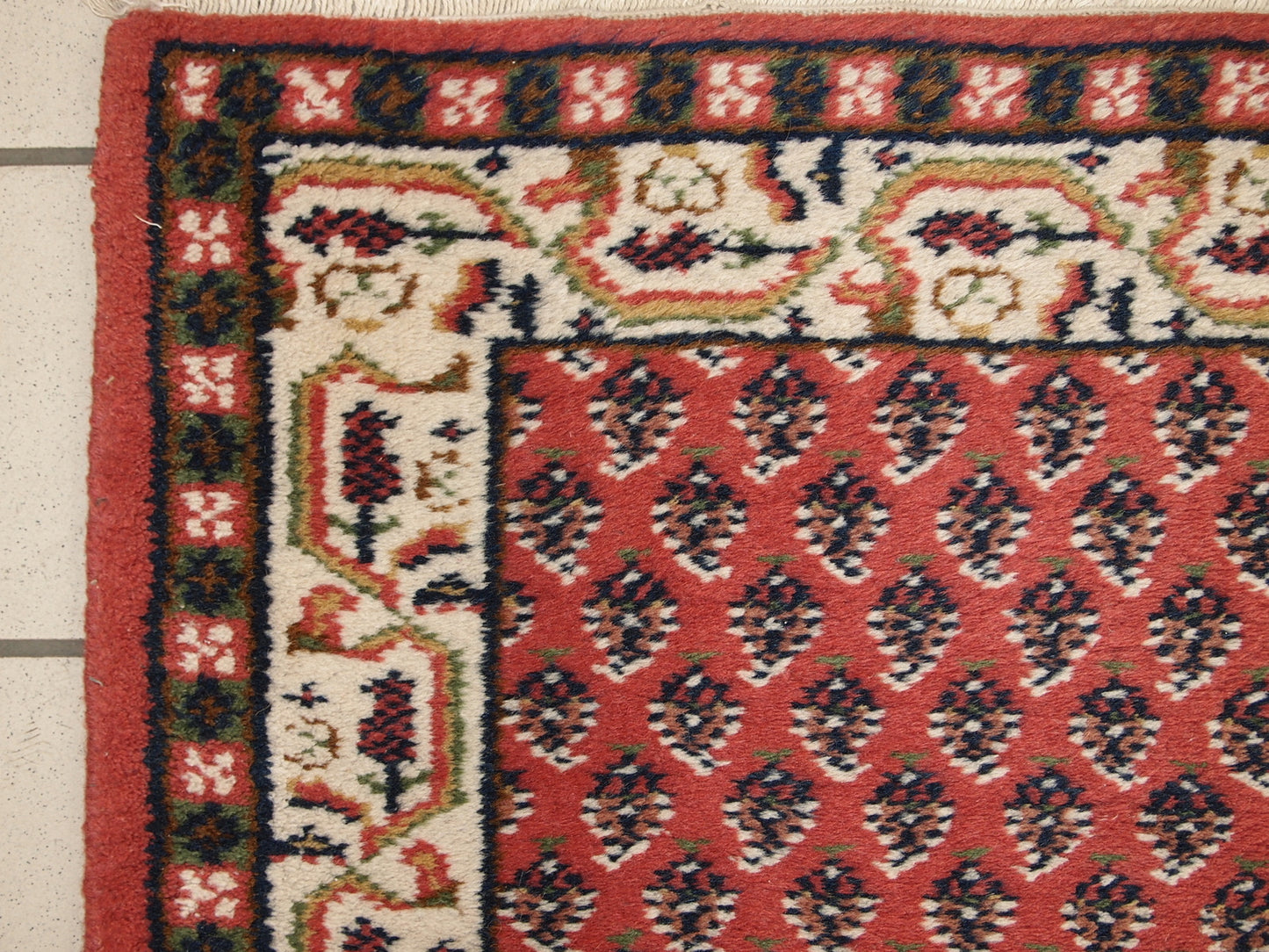 Handmade vintage small rug from India in red color. It is in original good condition from the end of 20th century.