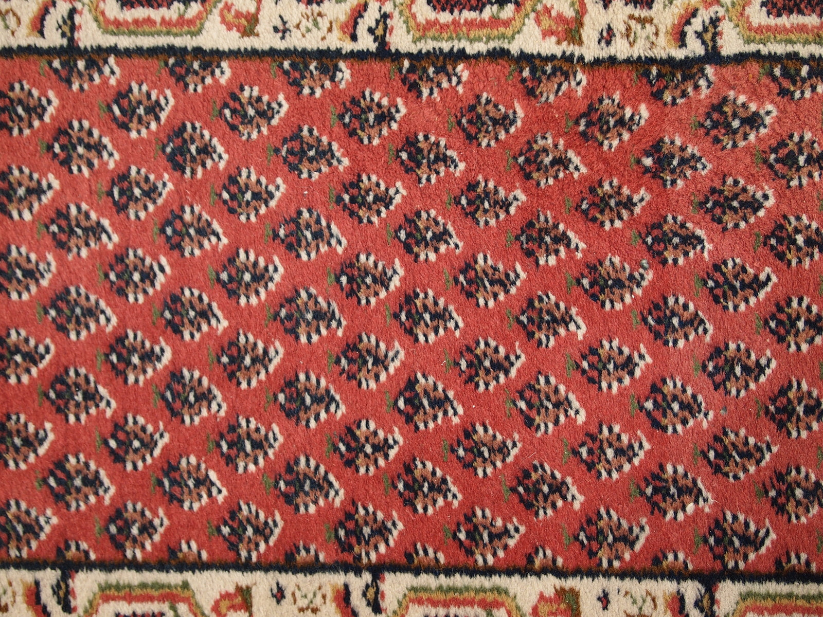 Handmade vintage small rug from India in red color. It is in original good condition from the end of 20th century.