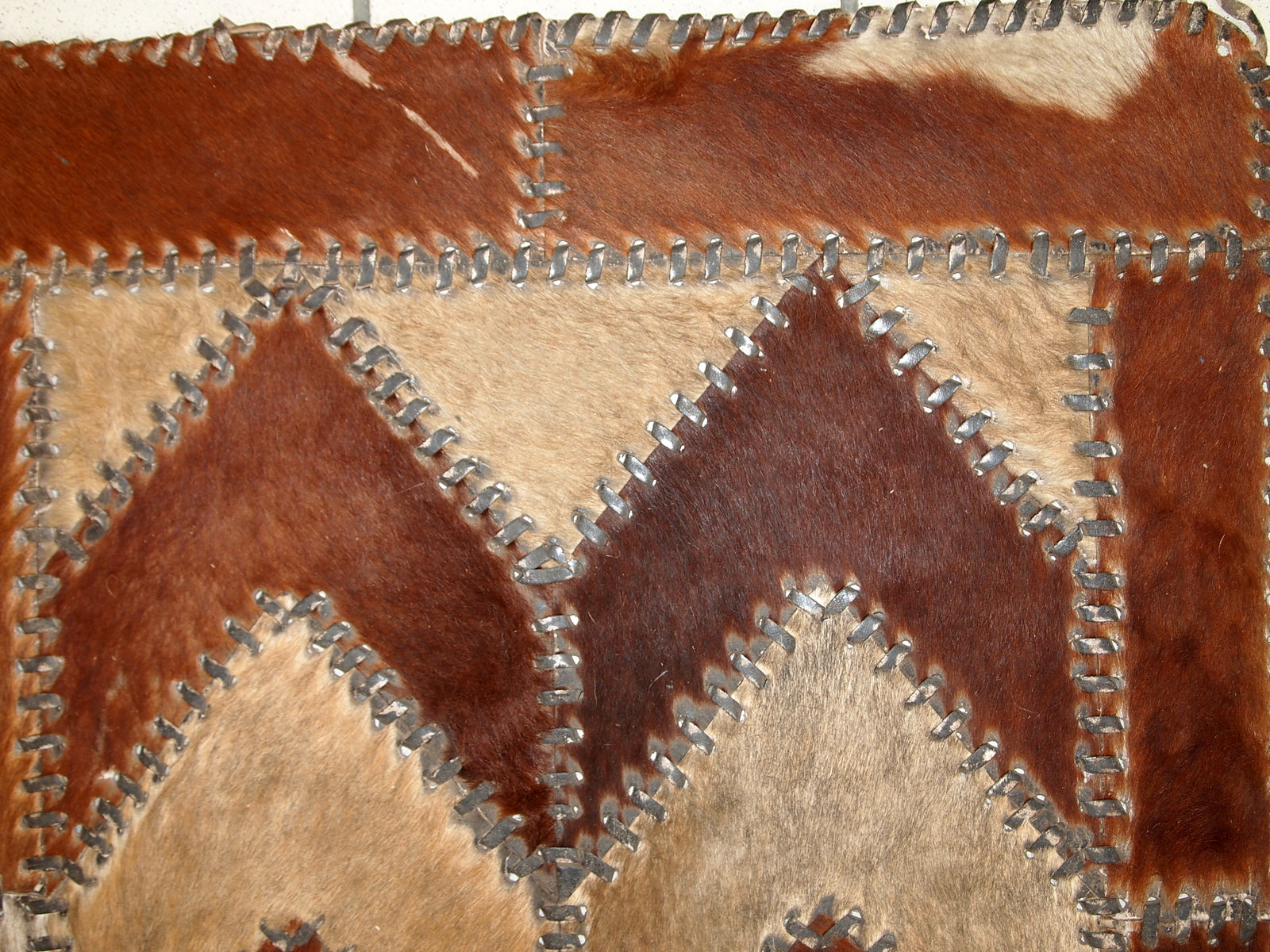 Handmade vintage rug from Europe made in cow skin. It is from the middle of 20th century in original condition, one corner is missing.