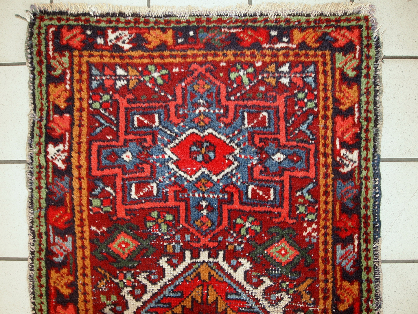 Handmade antique Persian Karajeh runner in distressed condition. It has been made in the beginning of 2àth century in red wool.