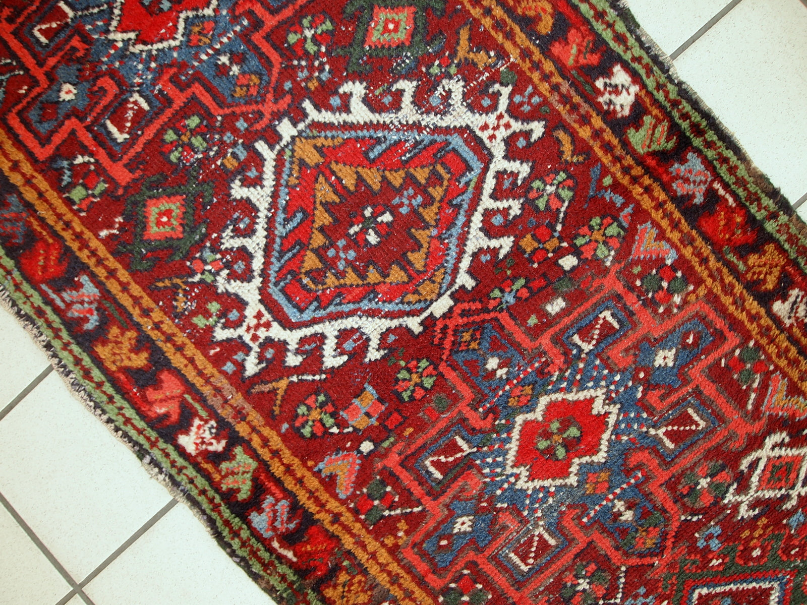 Handmade antique Persian Karajeh runner in distressed condition. It has been made in the beginning of 2àth century in red wool.