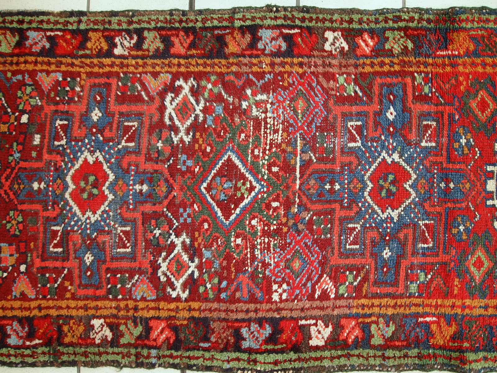 Handmade antique Persian Karajeh runner in distressed condition. It has been made in the beginning of 2àth century in red wool.