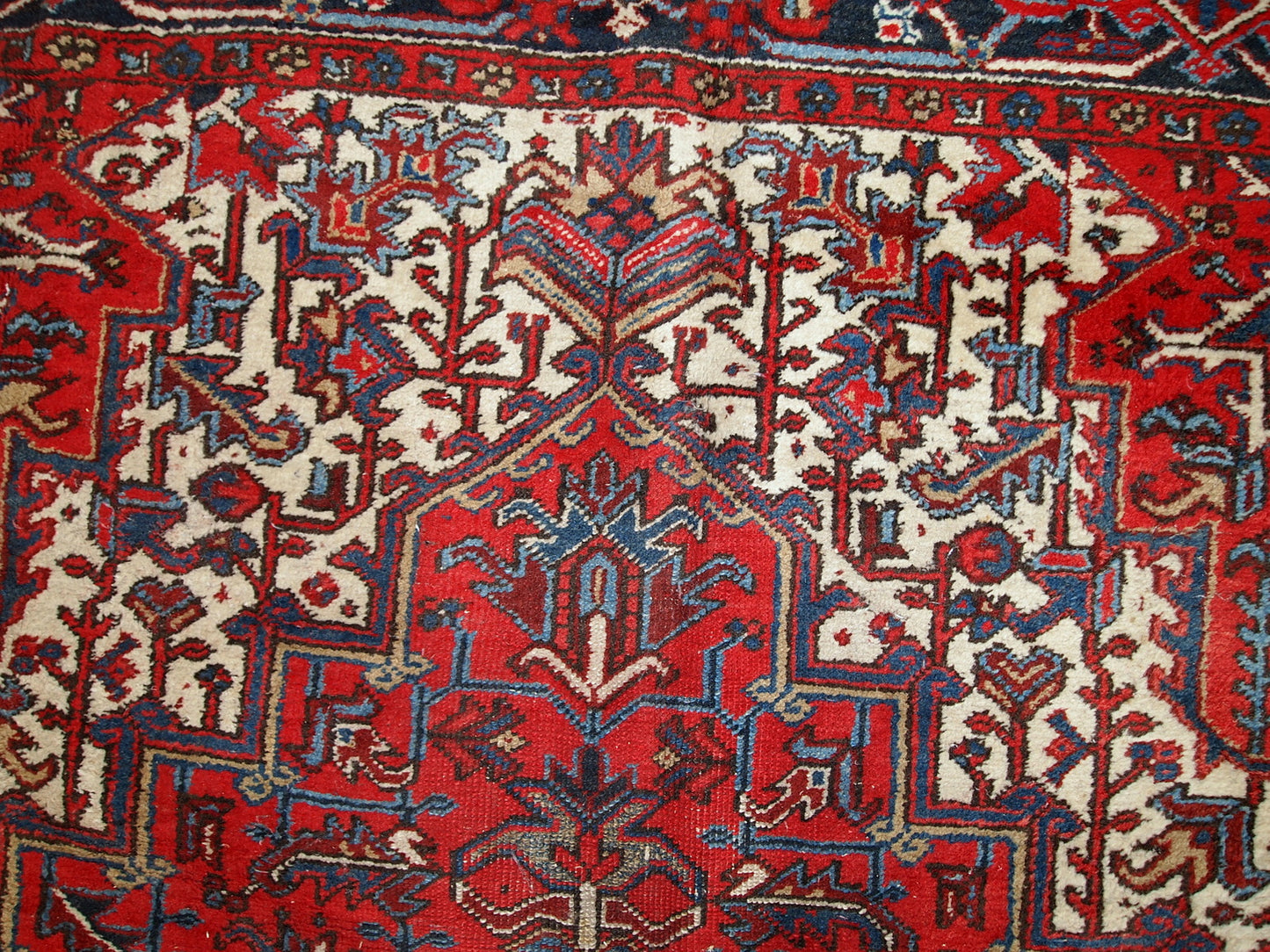 Handmade antique Persian Heriz rug from the middle of 20th century. The rug is in original condition, it has some low pile.