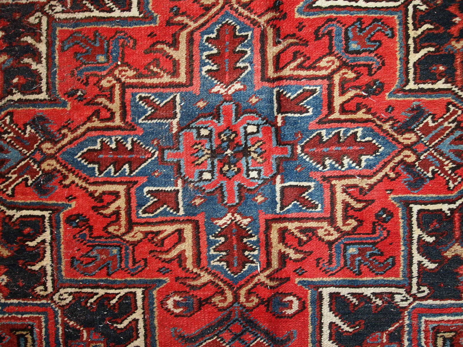 Handmade antique Persian Heriz rug from the middle of 20th century. The rug is in original condition, it has some low pile.