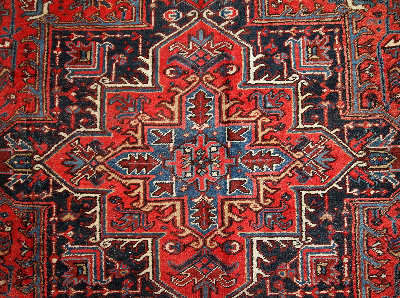 Handmade antique Persian Heriz rug from the middle of 20th century. The rug is in original condition, it has some low pile.