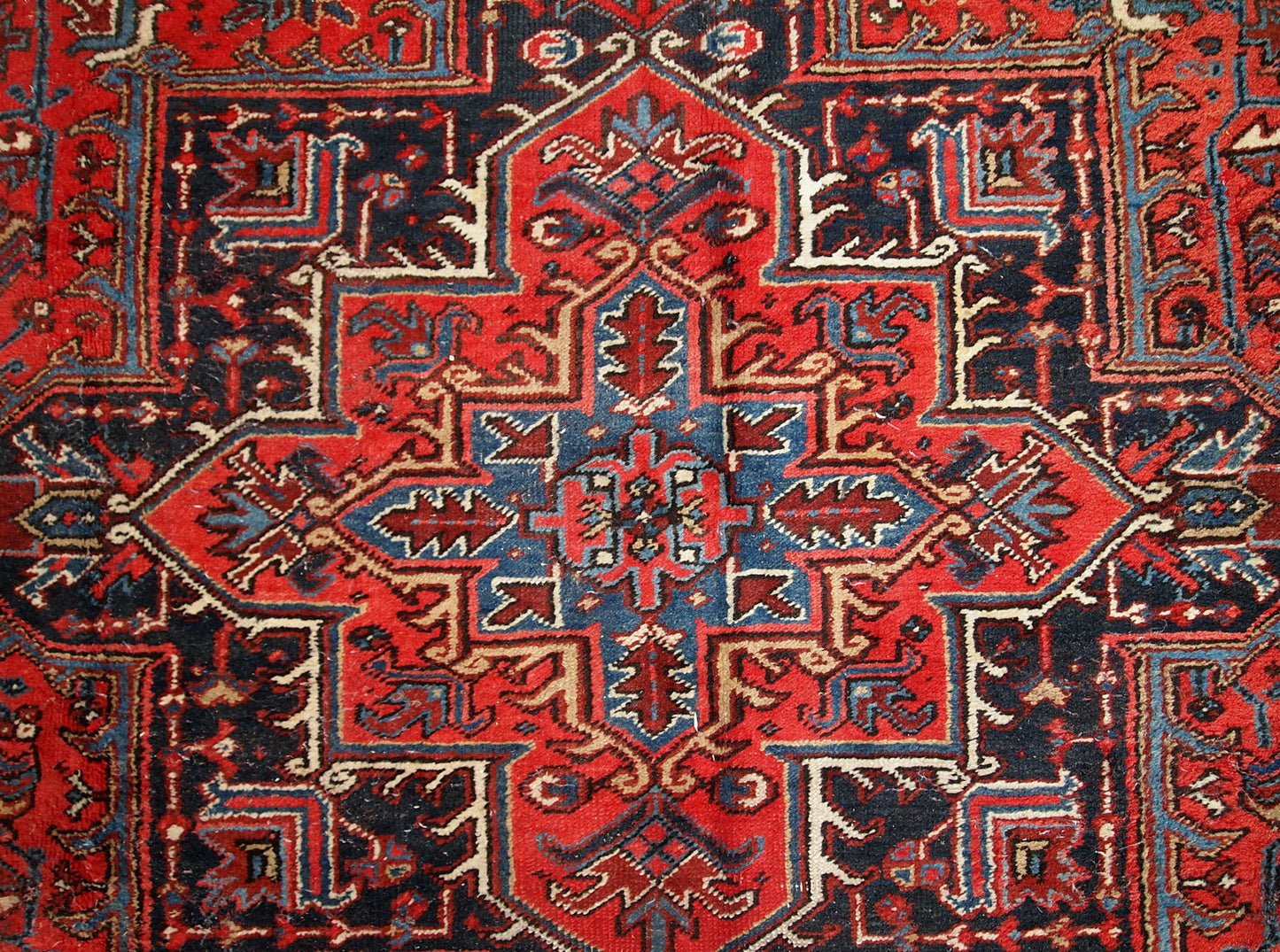 Handmade antique Persian Heriz rug from the middle of 20th century. The rug is in original condition, it has some low pile.