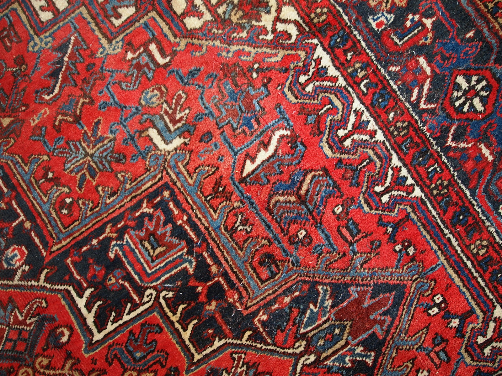 Handmade antique Persian Heriz rug from the middle of 20th century. The rug is in original condition, it has some low pile.