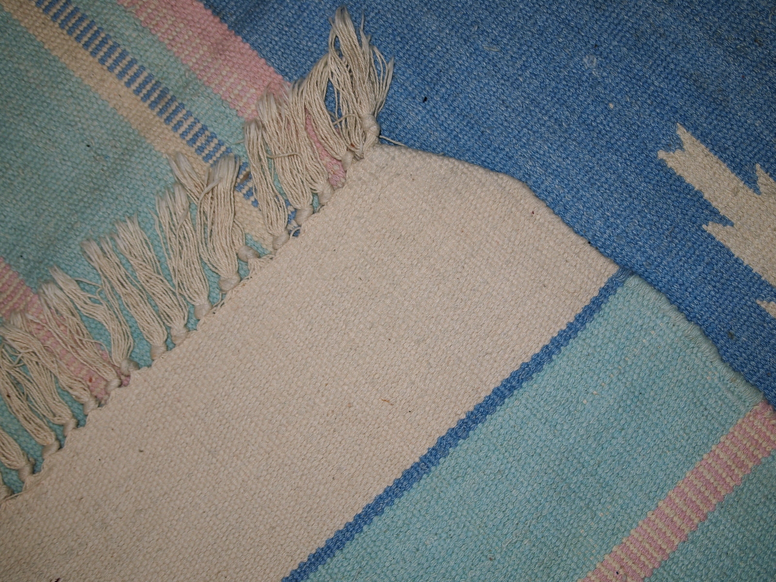 Detail shot of the kilim's vintage 1960s design with sea blue and pink stripes