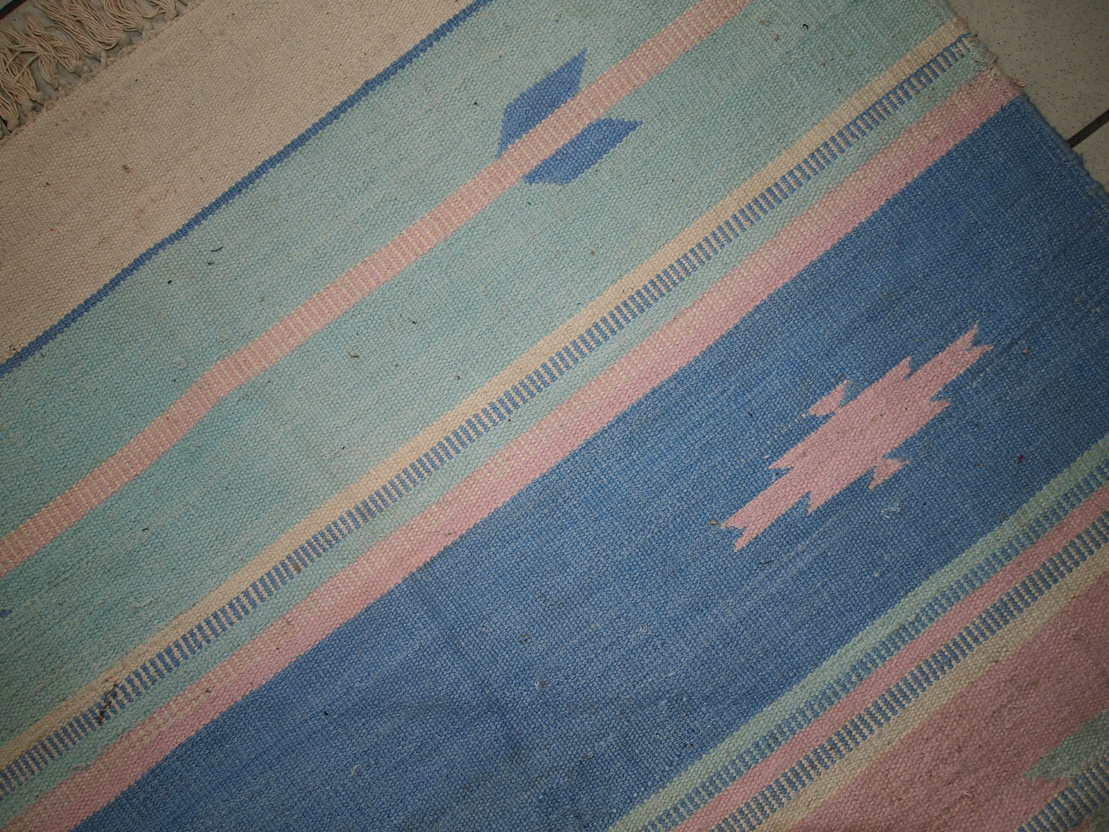 Detail shot of the kilim's pastel blue and sea blue stripes.