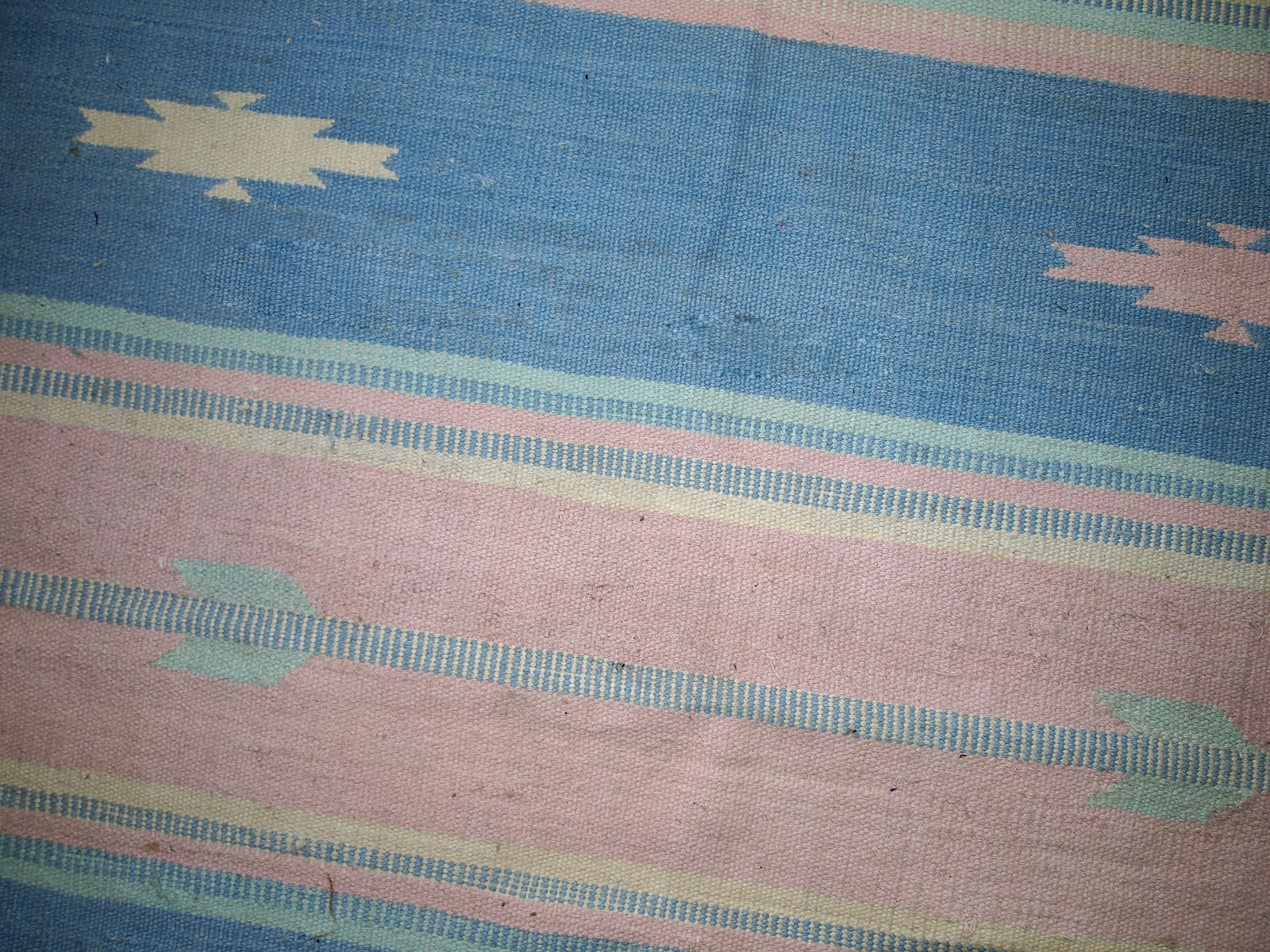 Close-up of the kilim's vibrant pink and beige stripes.