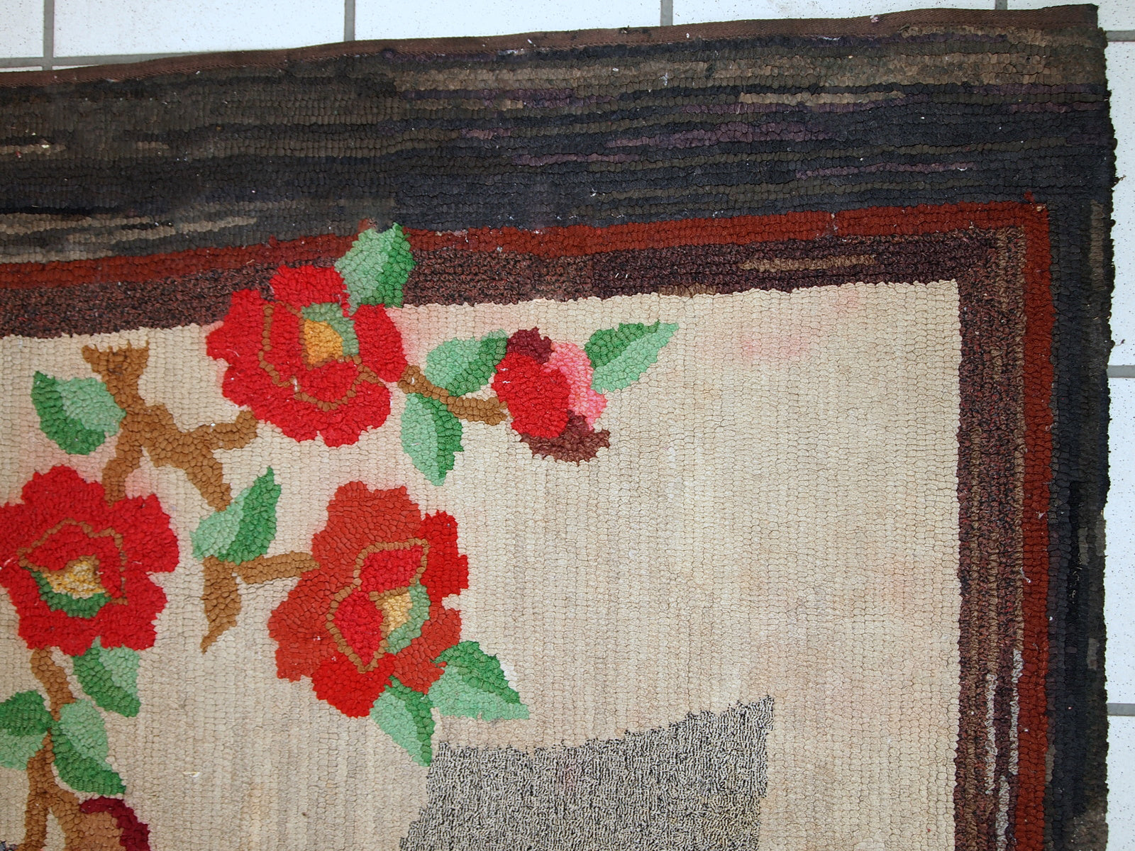 Handmade antique American Hooked rug in beige wool. The rug has been made in the beginning of 20th century in United States of America. It is in original condition, it has some color run, age discoloration and a little crooked.