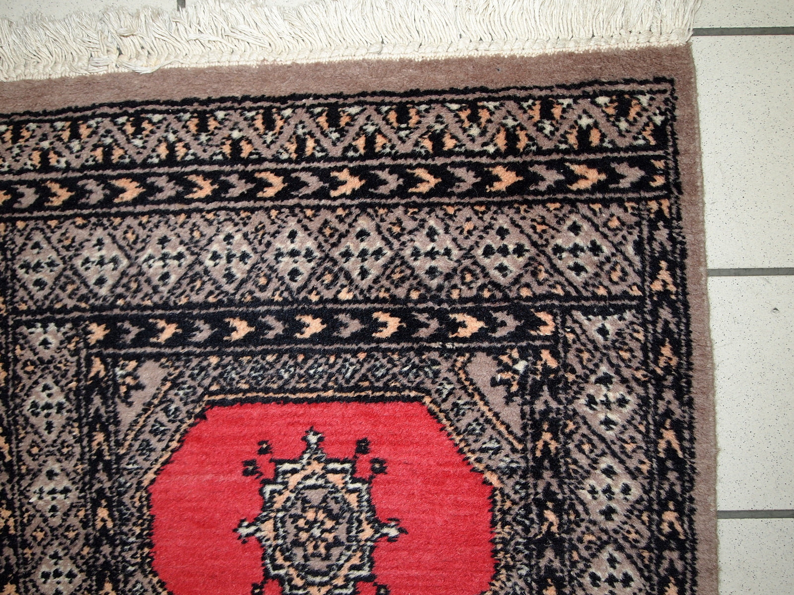 Vintage Uzbek Bukhara rug in original good condition from the middle of 20th century. The rug has been made in red wool. 