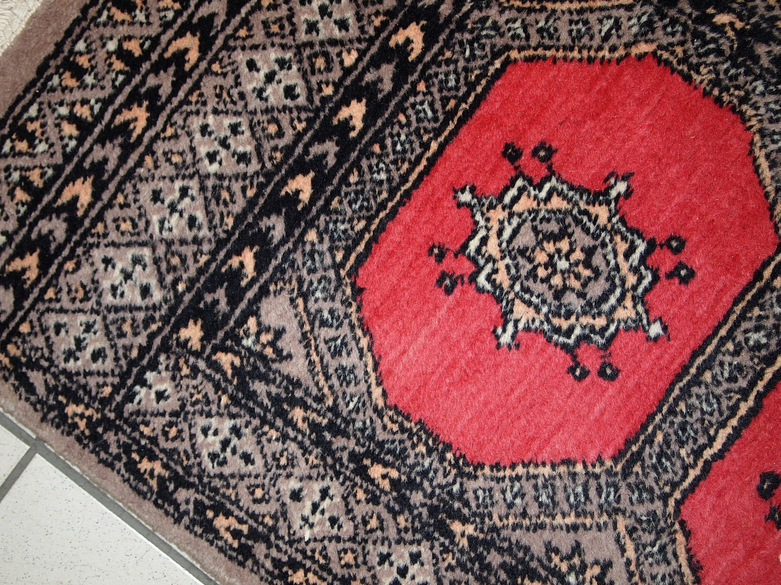 Vintage Uzbek Bukhara rug in original good condition from the middle of 20th century. The rug has been made in red wool. 