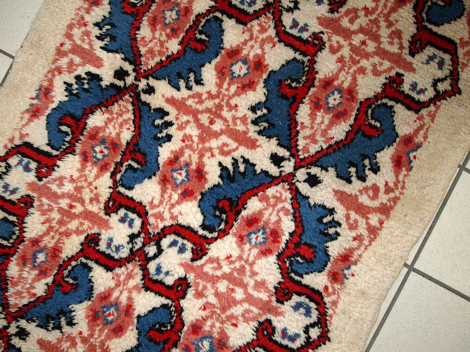 Handmade vintage Moroccan Berber rug in white, blue and red wool. The rug is in original good condition, from the end of 20th century.