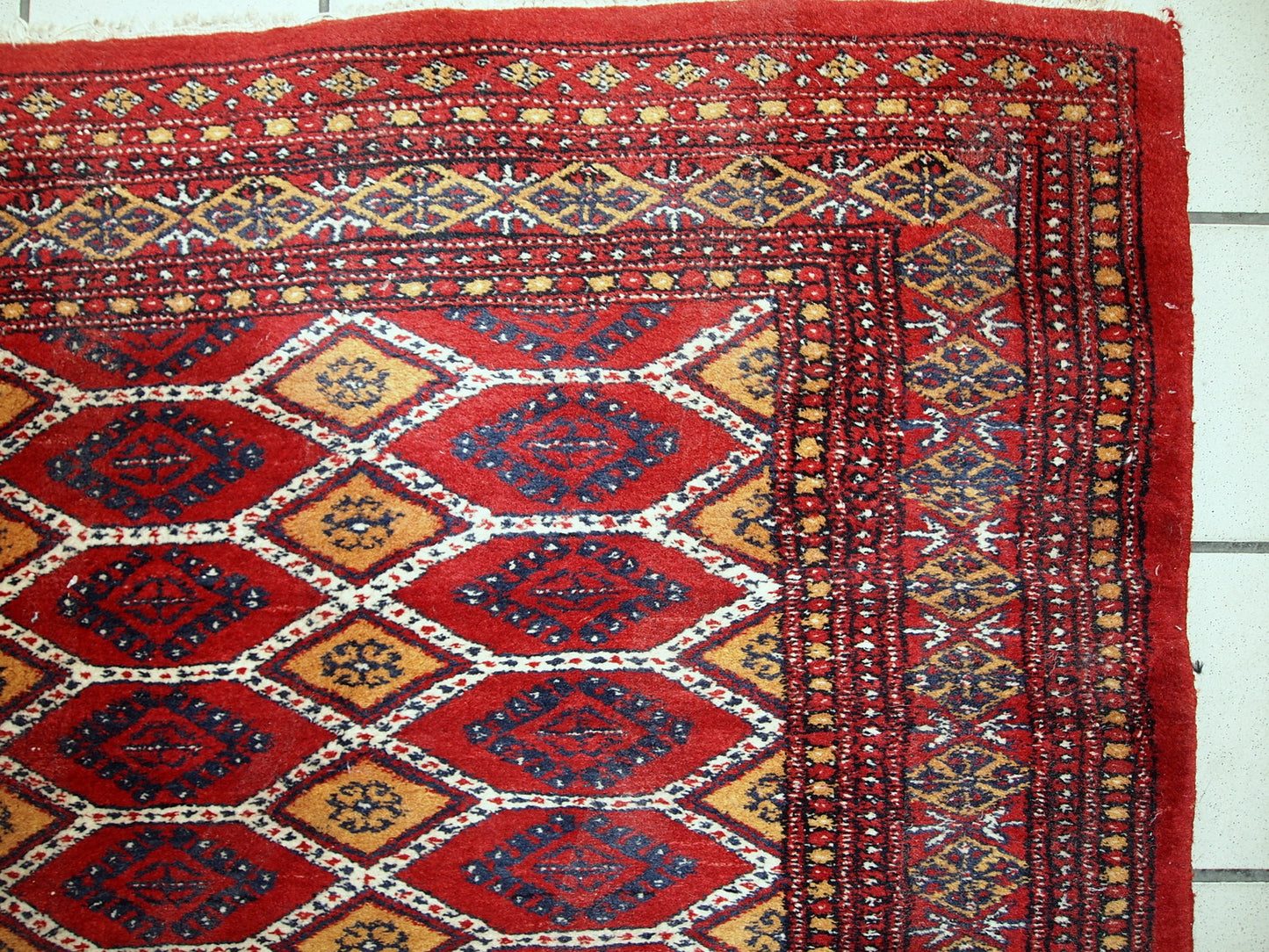 Vintage Uzbek Bukhara rug in red and yellow wool. The rug is from the end of 20th century in original good condition.