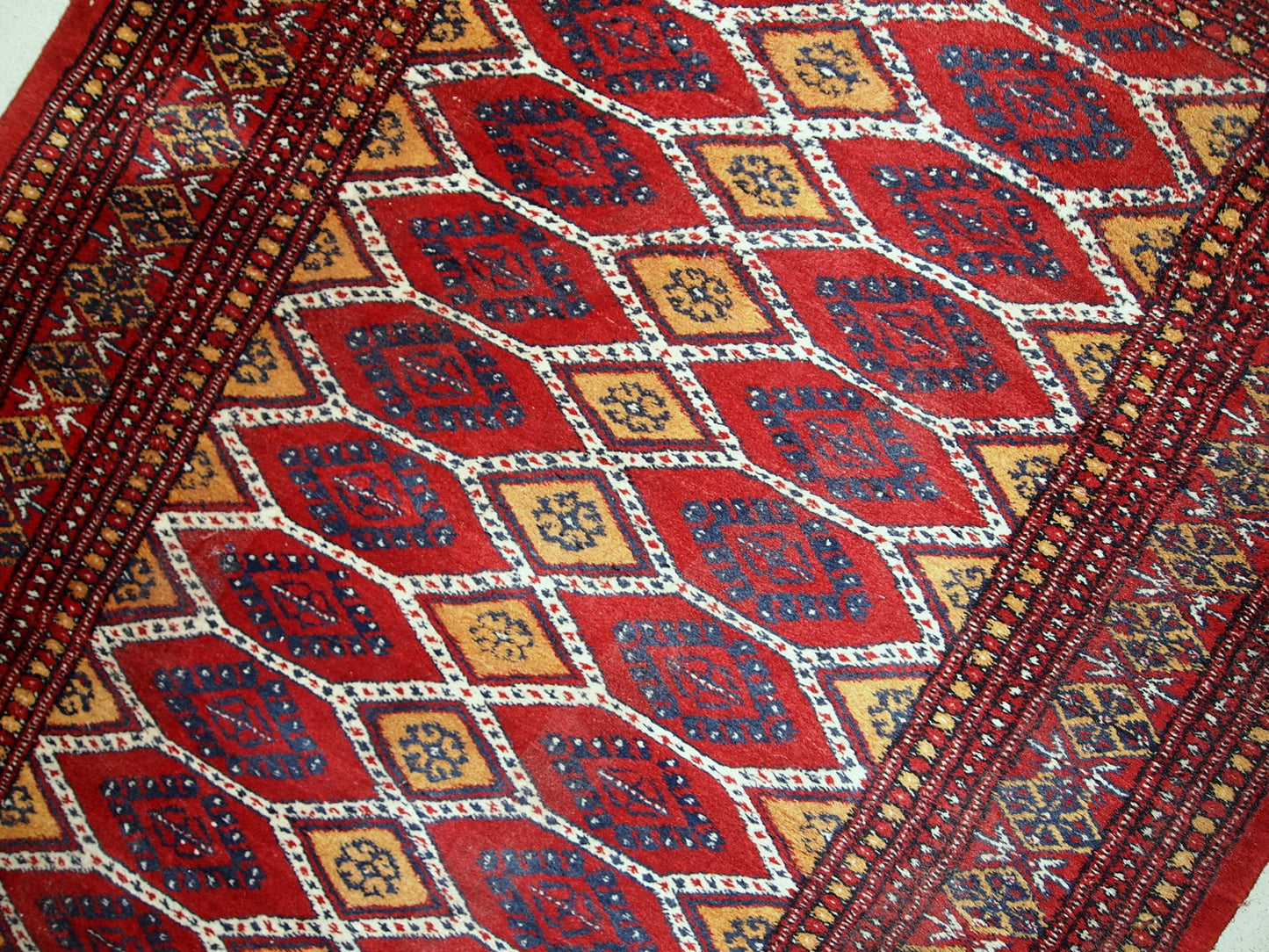 Vintage Uzbek Bukhara rug in red and yellow wool. The rug is from the end of 20th century in original good condition.