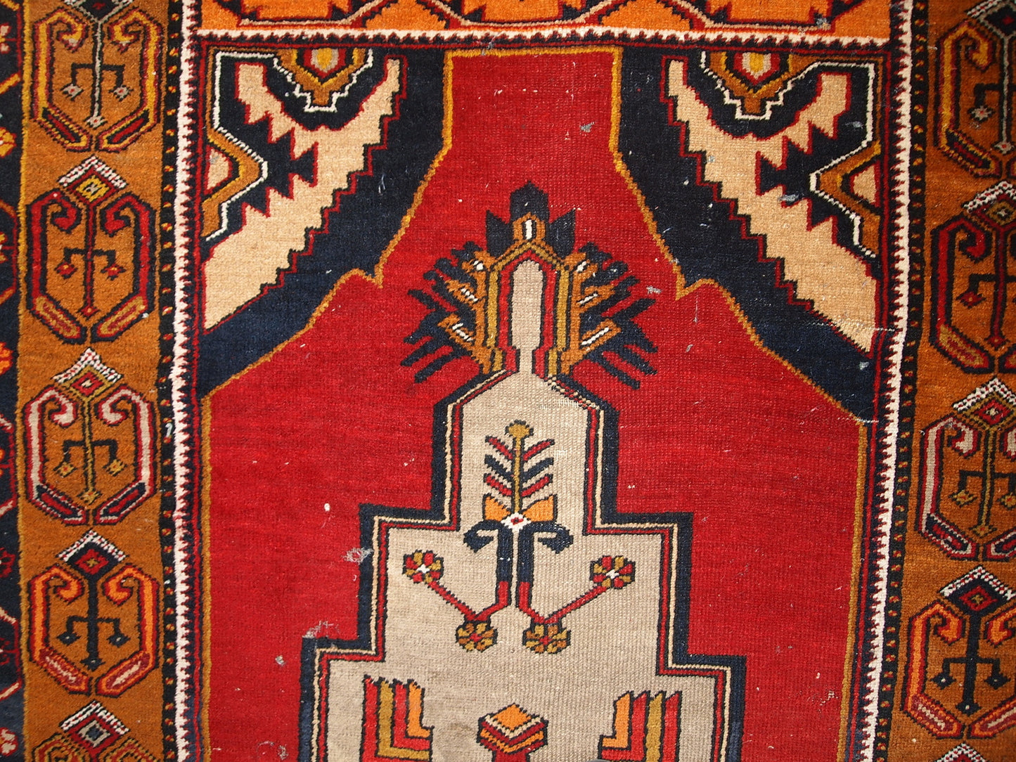 Antique Turkish Anatolian rug in distressed condition. The rug made in traditional Anatolian design in red, yellow, navy blue and grey shades. ​The rug made in the beginning of 20th century.