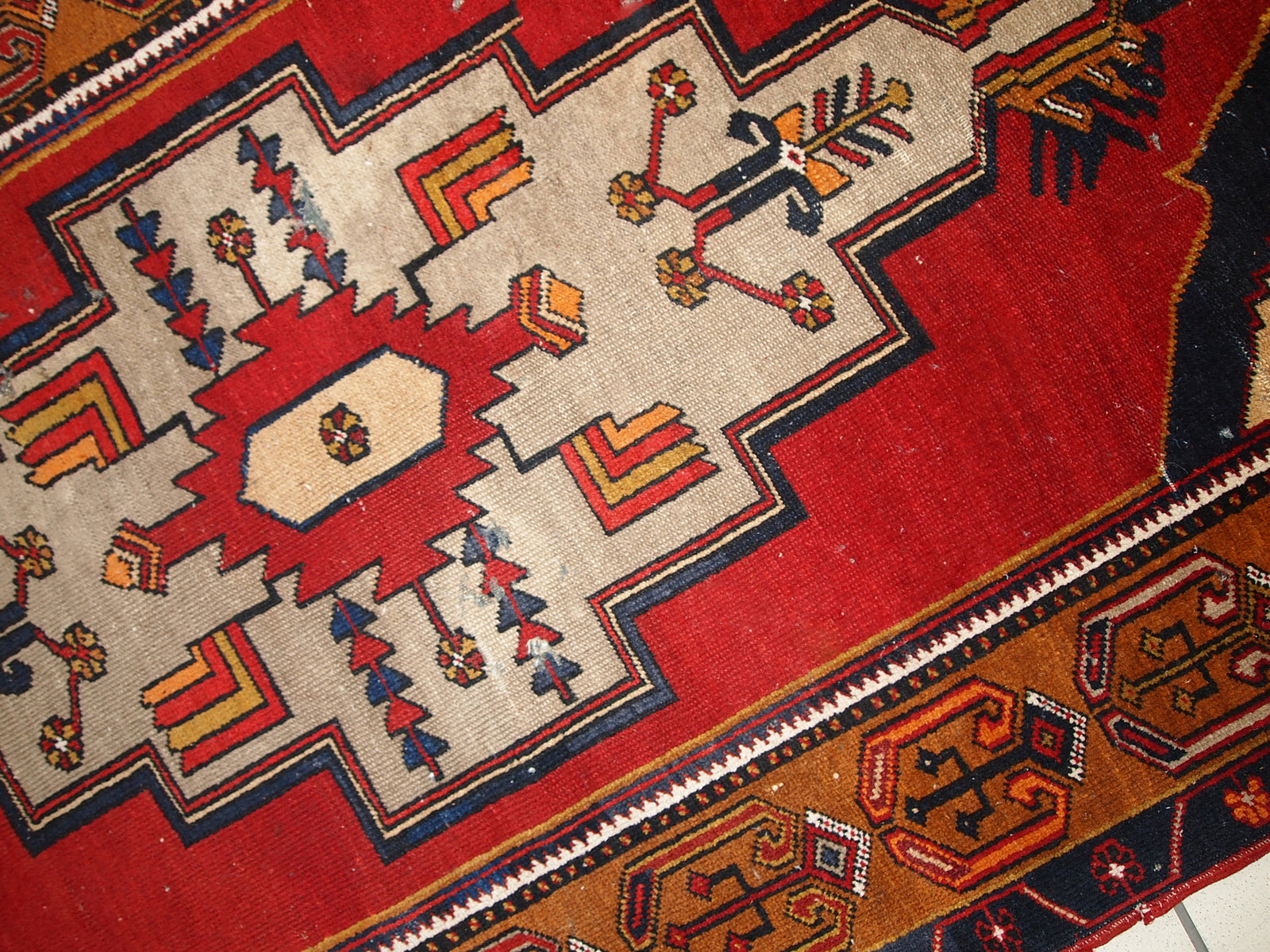 Antique Turkish Anatolian rug in distressed condition. The rug made in traditional Anatolian design in red, yellow, navy blue and grey shades. ​The rug made in the beginning of 20th century.