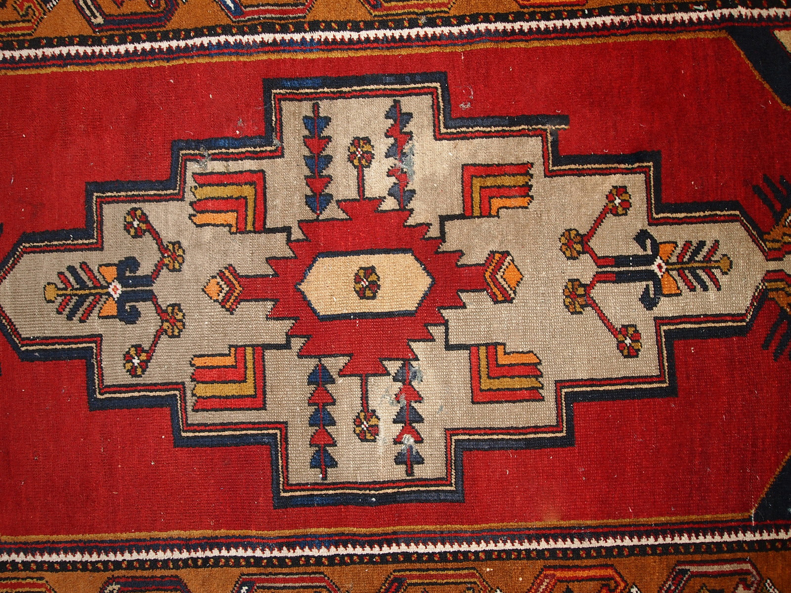 Antique Turkish Anatolian rug in distressed condition. The rug made in traditional Anatolian design in red, yellow, navy blue and grey shades. ​The rug made in the beginning of 20th century.