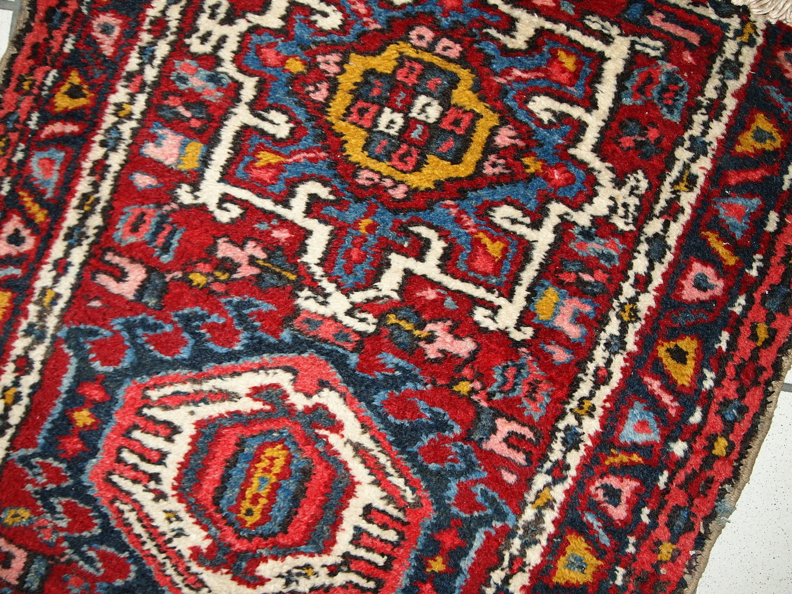 Handmade antique Persian Karajeh rug in original good condition. It has been made in the beginning of 20th century in red wool.