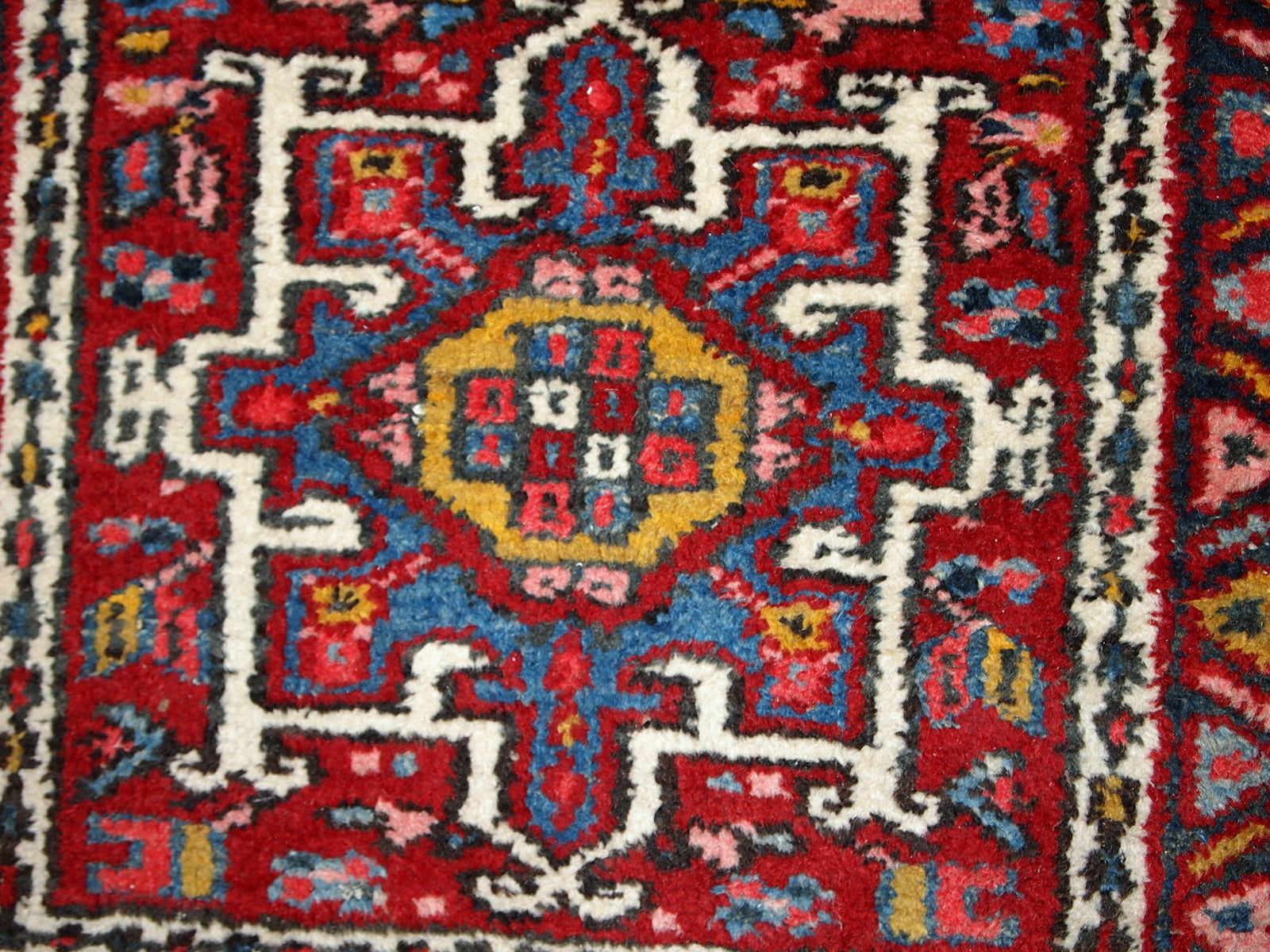 Handmade antique Persian Karajeh rug in original good condition. It has been made in the beginning of 20th century in red wool.
