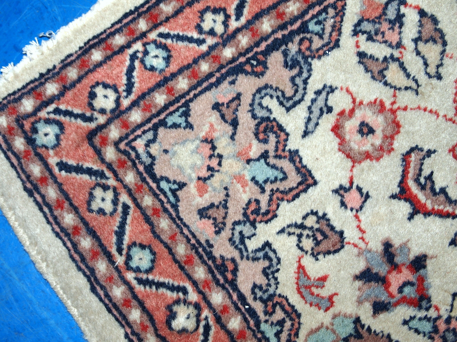 Vintage handmade Indian rug from the end of 20th century. The rug is in original good condition in a beige shade and floral design.