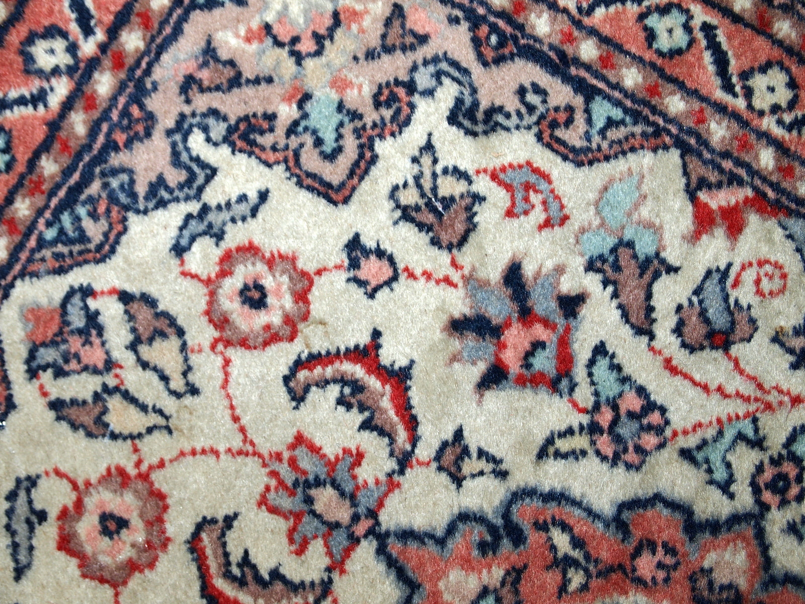 Vintage handmade Indian rug from the end of 20th century. The rug is in original good condition in a beige shade and floral design.