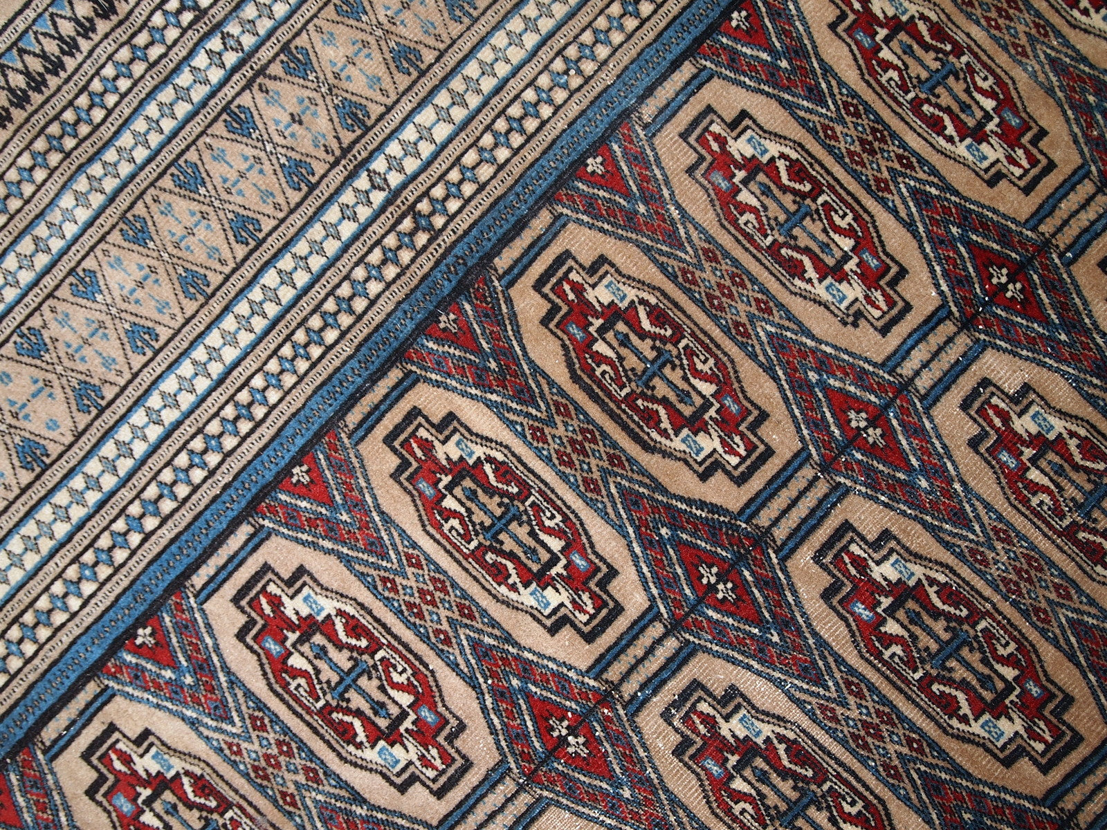 Handmade vintage Uzbek Bukhara rug in original good condition. The rug is from the middle of 20th century in brown and burgundy shades.