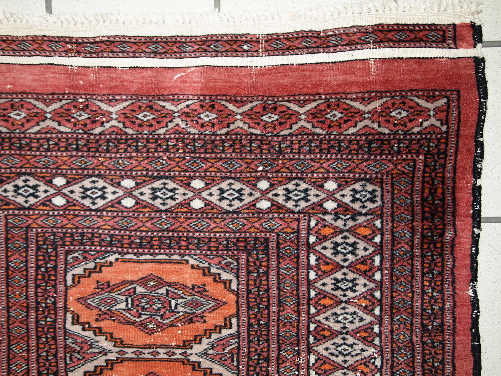 Handmade vintage Uzbek Bukhara distressed rug in traditional design. The rug is from the end of 20th century, it has some low pile.