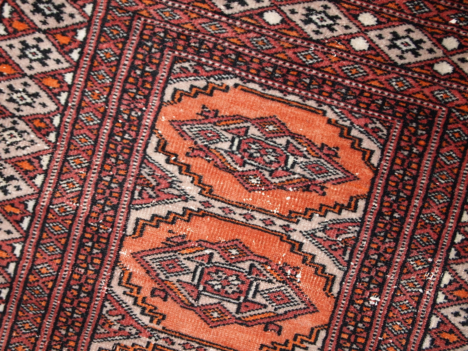 Handmade vintage Uzbek Bukhara distressed rug in traditional design. The rug is from the end of 20th century, it has some low pile.