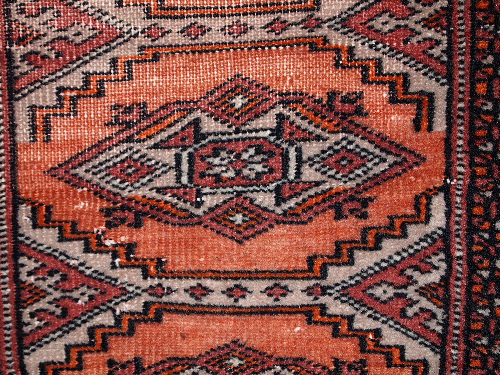 Handmade vintage Uzbek Bukhara distressed rug in traditional design. The rug is from the end of 20th century, it has some low pile.