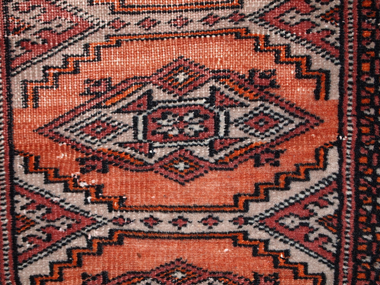 Handmade vintage Uzbek Bukhara distressed rug in traditional design. The rug is from the end of 20th century, it has some low pile.