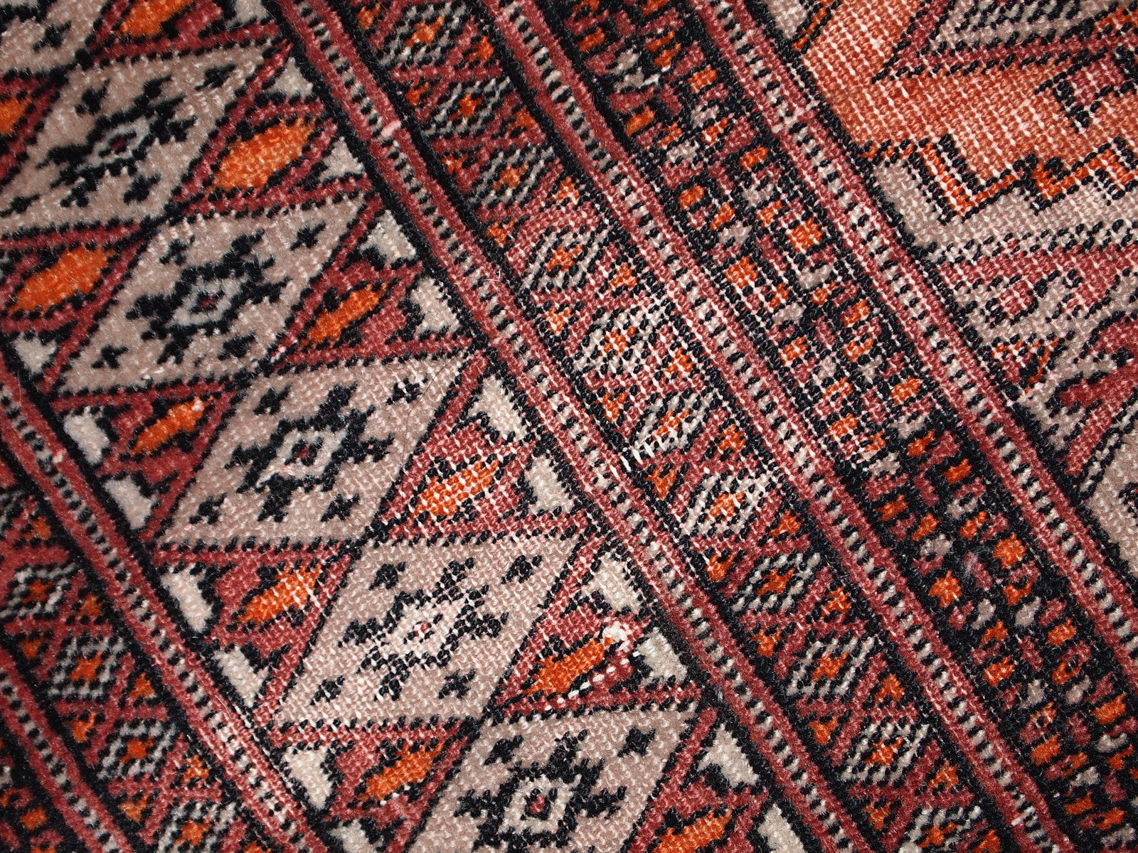 Handmade vintage Uzbek Bukhara distressed rug in traditional design. The rug is from the end of 20th century, it has some low pile.