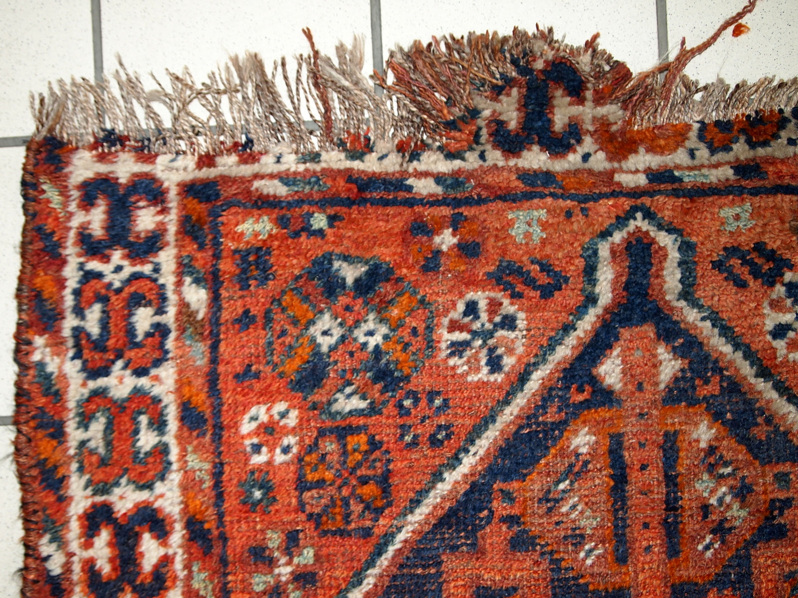 Handmade antique Middle Eastern rug in traditional design. The rug is from the beginning of 20th century in distressed condition. 